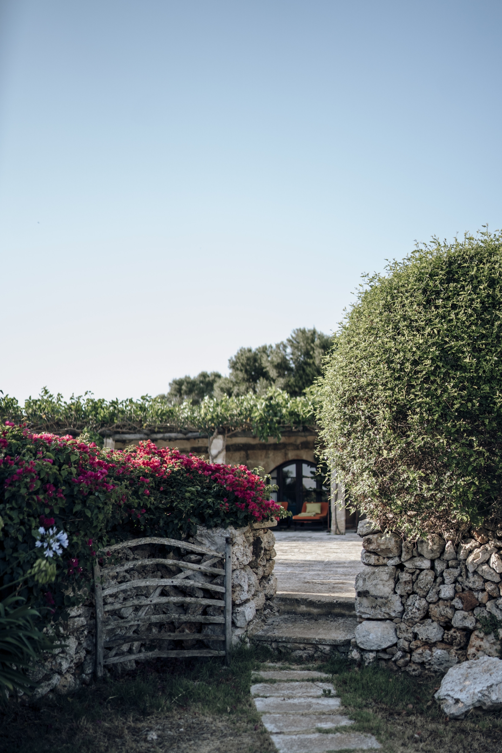 gate between hedge and flowers leading to Menorcan luxury villa Binicalaf