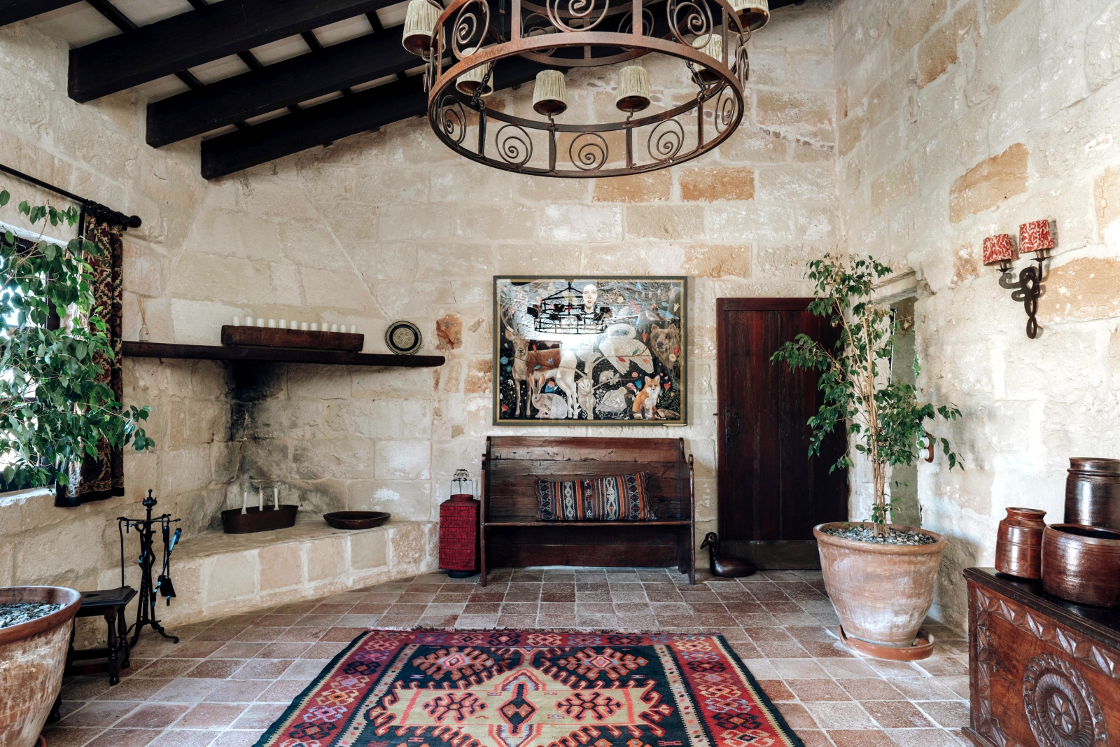 Entrance hall decorated with art, rugs and plants at Menorcan luxury villa Binicalaf