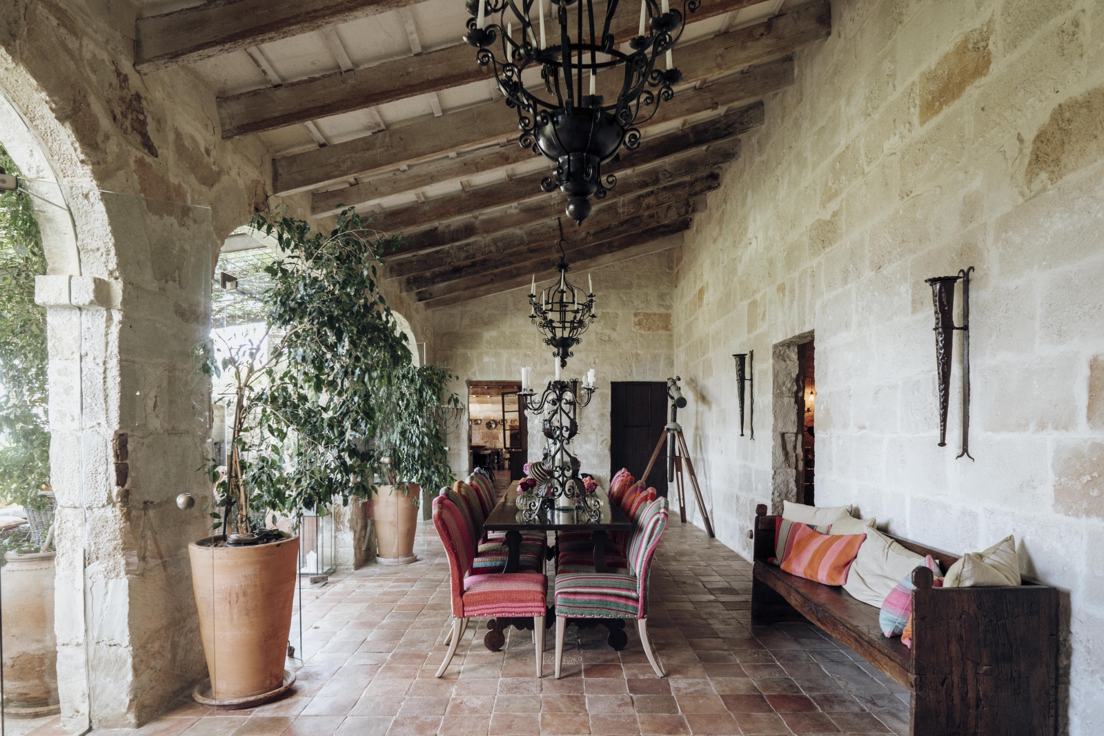 indoor dining area with extensive windows and glass doors leading to a shaded courtyard
