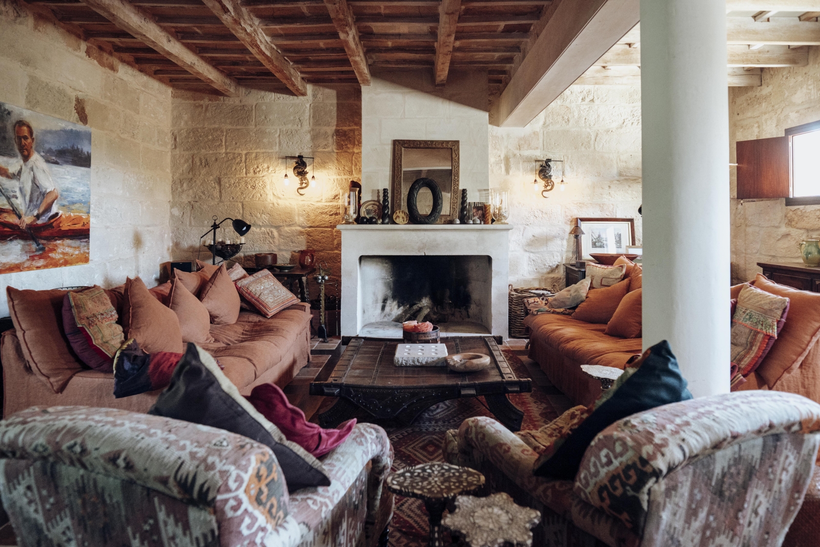 Indoor lounge with comfortable seating and open fire place at luxury villa Binicalaf