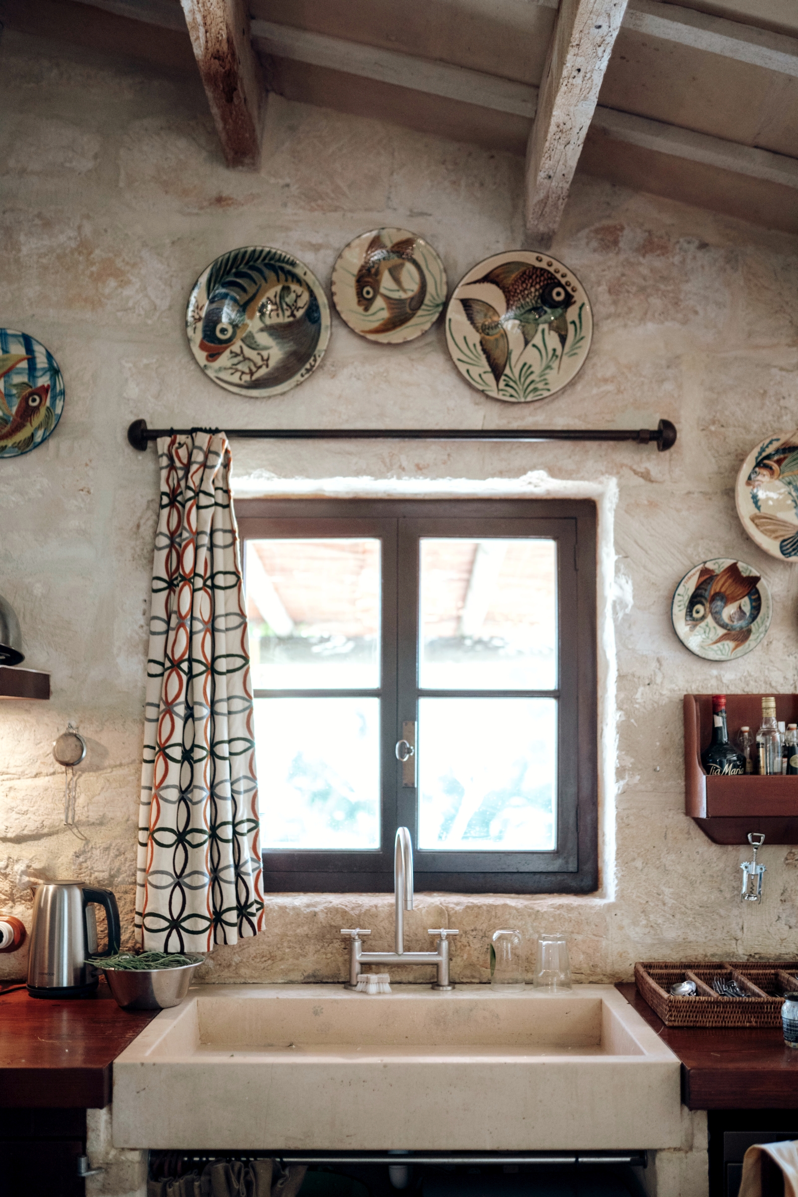 Kitchen sink with views over the terrace and decorative plates o nthe wall at luxury villa Binicalaf