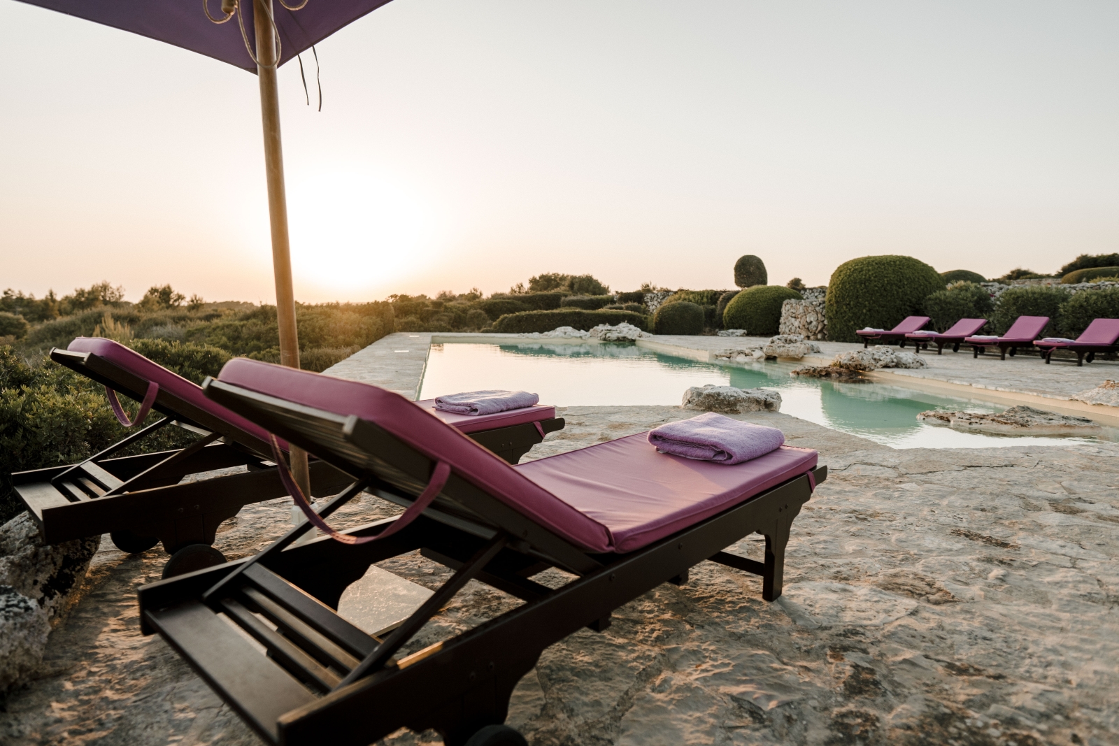 two loungers overlooking the pool of luxury villa Binicalaf at sunset