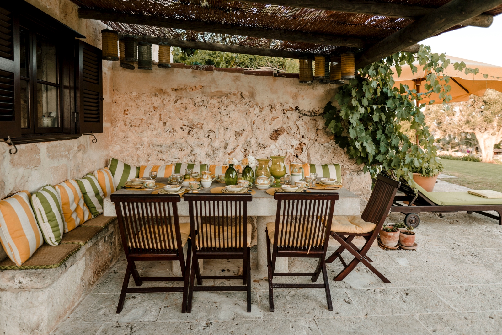 Cosy outdoor dining area by ivorycovered wall at Binicalaf