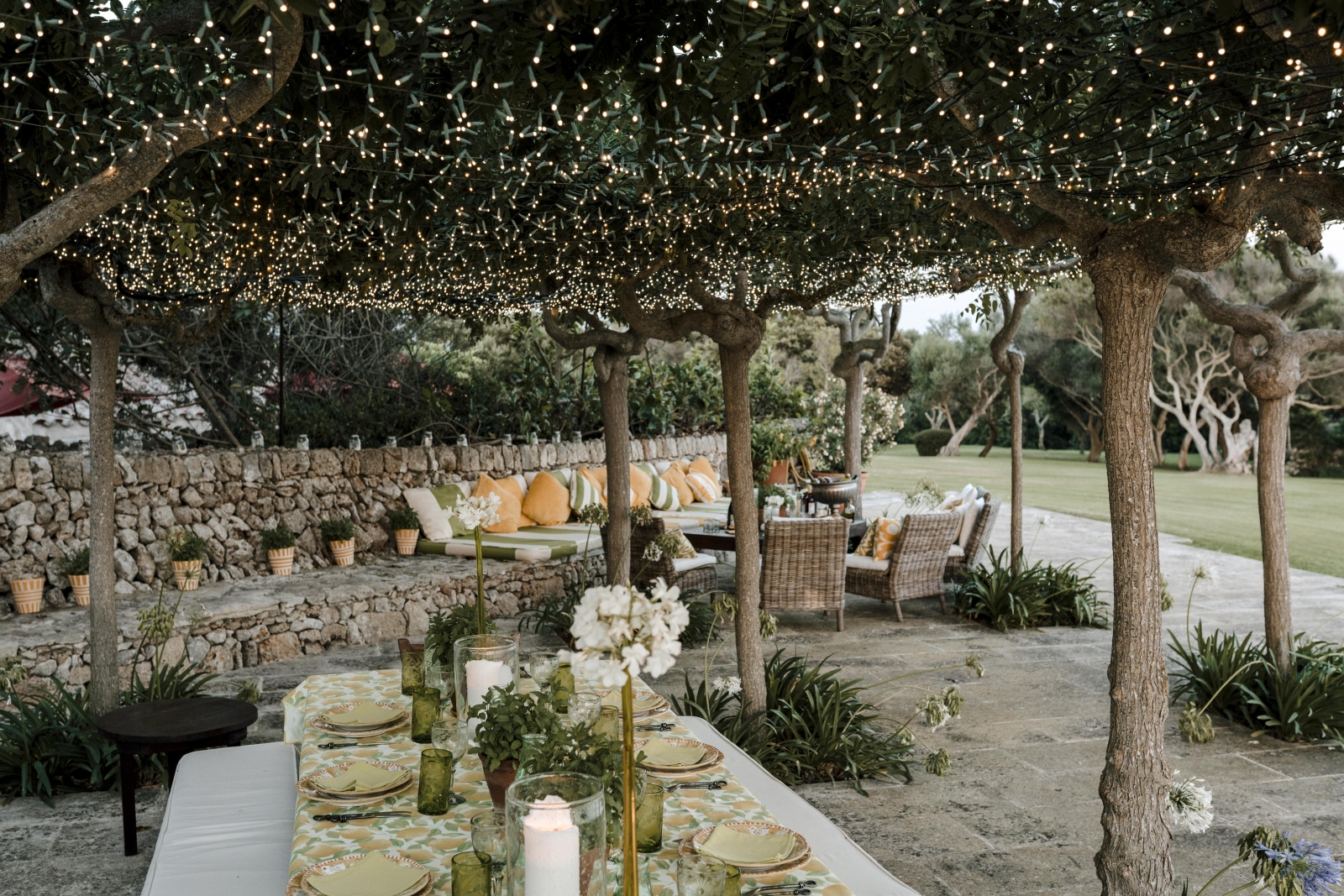 Dining table and lounge area under fairy lights at Binicalaf, luxury villa on Menorca