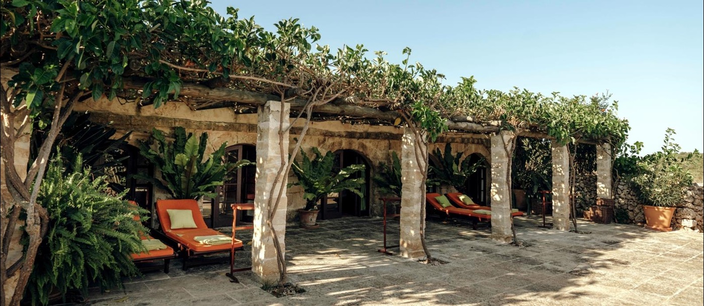 Shaded loungers along the main building of luxury villa binicalaf on Menorca