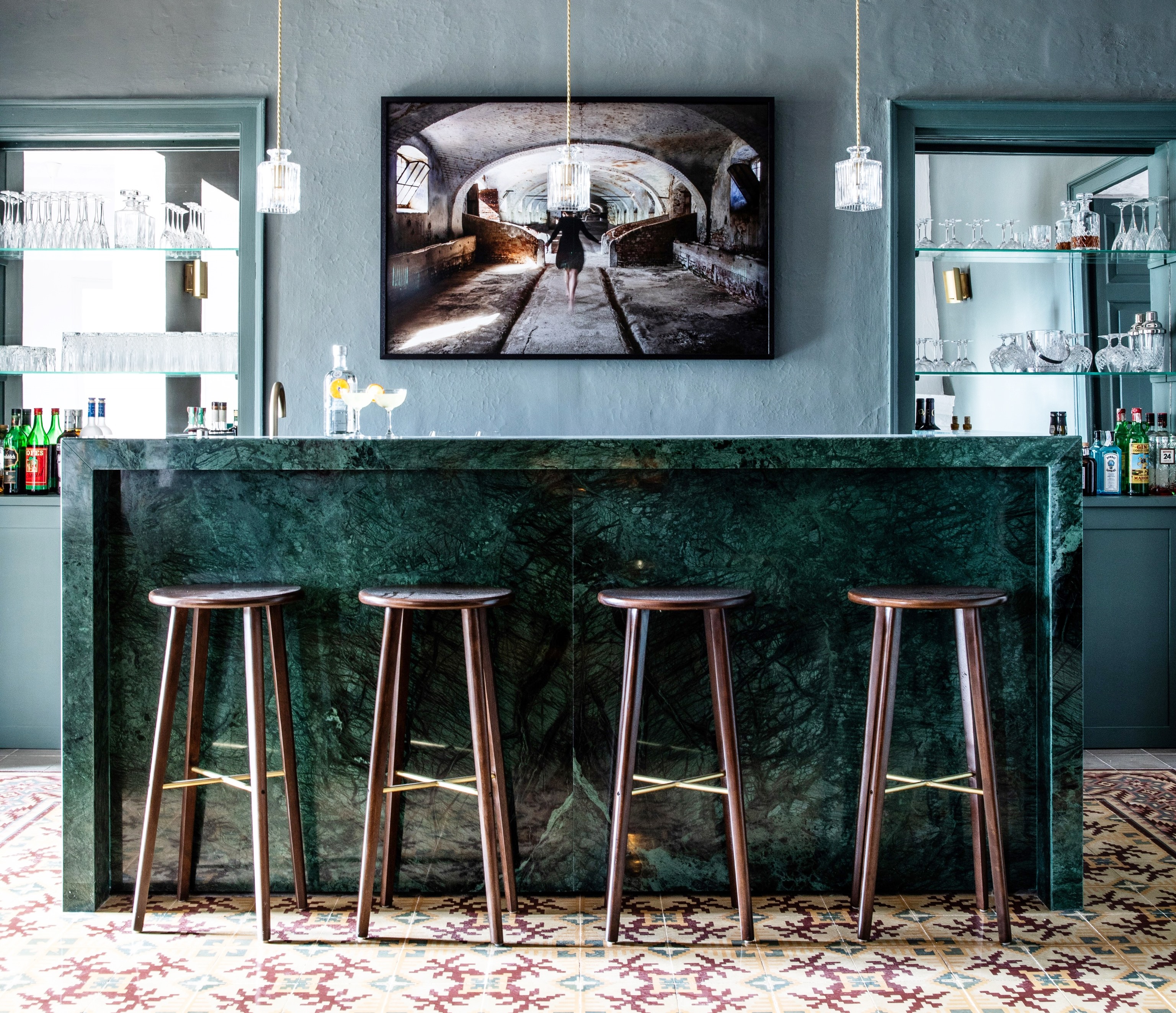 green marble bar with four bar stools and mirror behind on the wall at luxury villa Casa Benedicta in Menorca