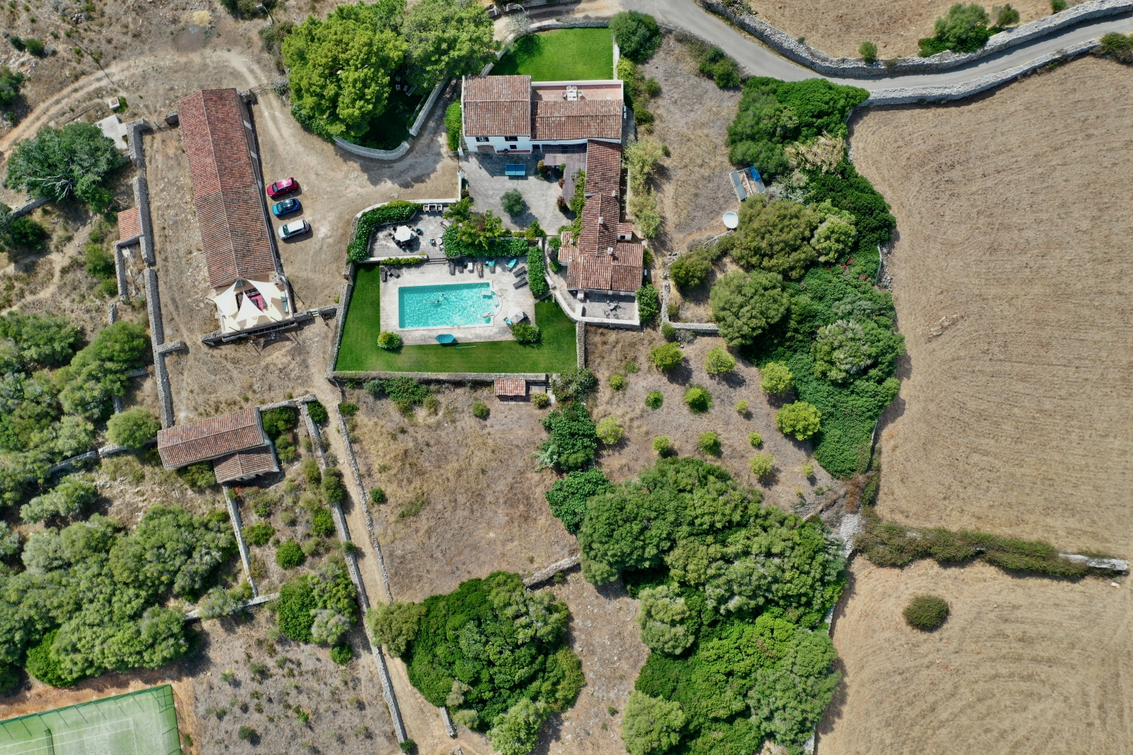 Aerial view of villa, pool, garden and tennis court at Finca Tortuga in Menorca, Spain