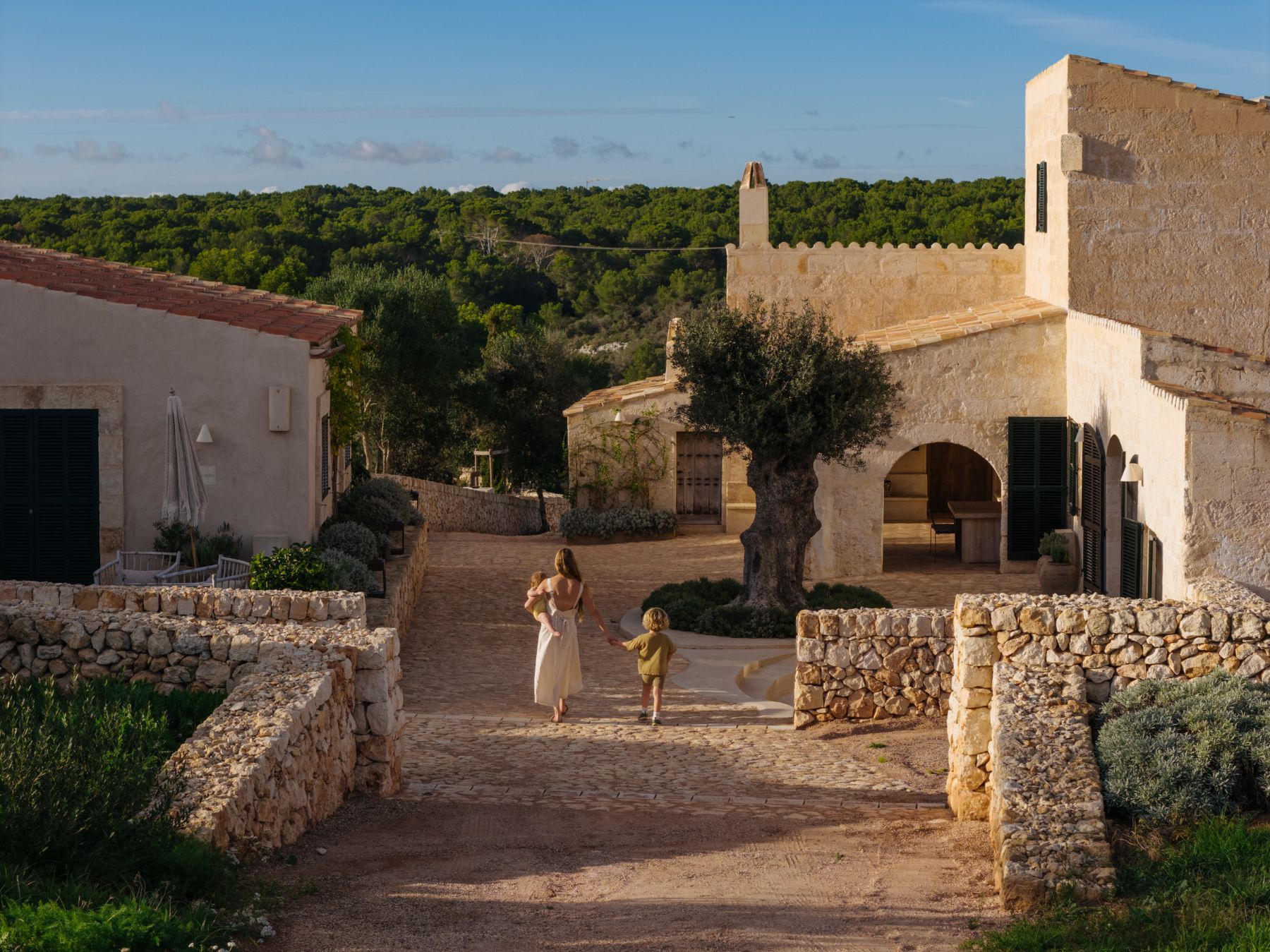 Mother and children walking into entrance of Villa Solana, Menorca
