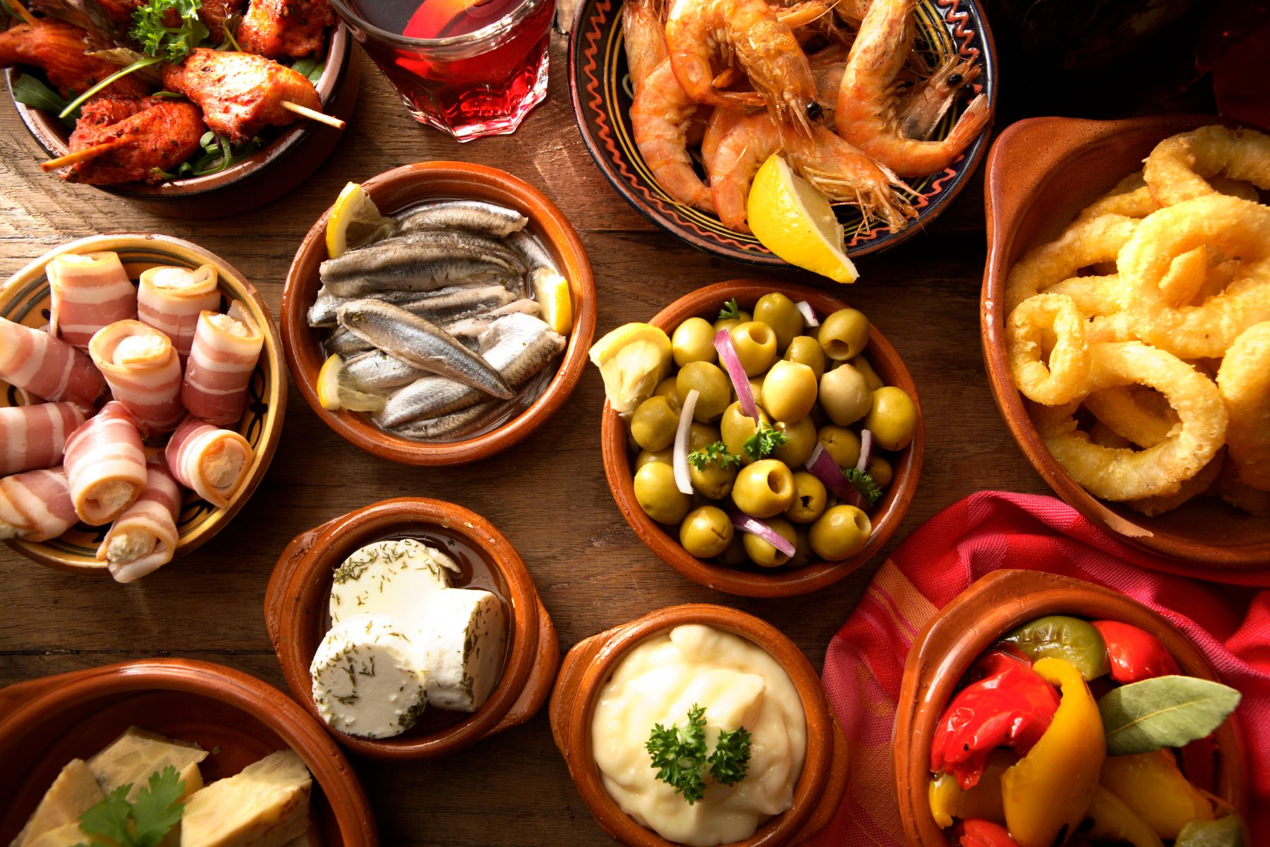 A selection of Spanish tapas in earthenware dishes