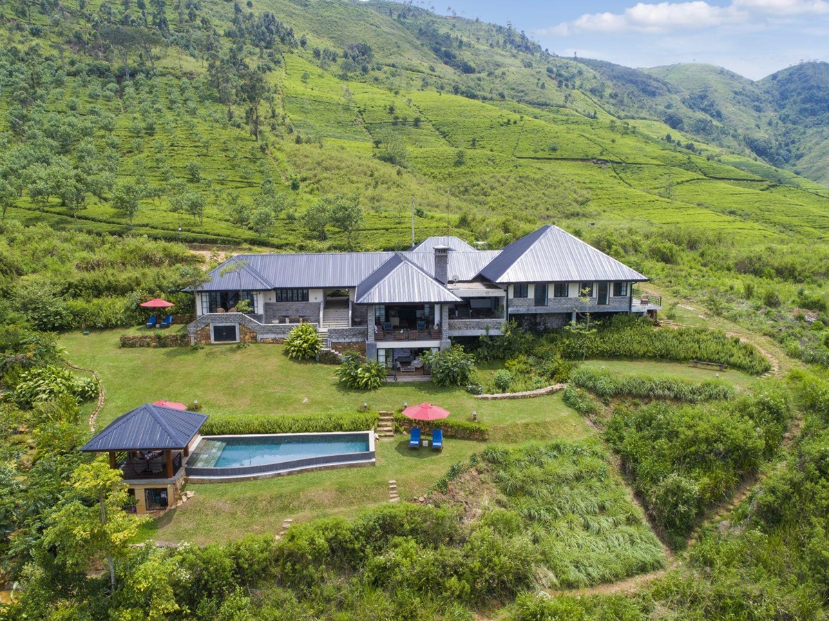 A aerial view of Camelia Hill tea bungalow in Sri Lanka set among tea plantations with mountains in the background