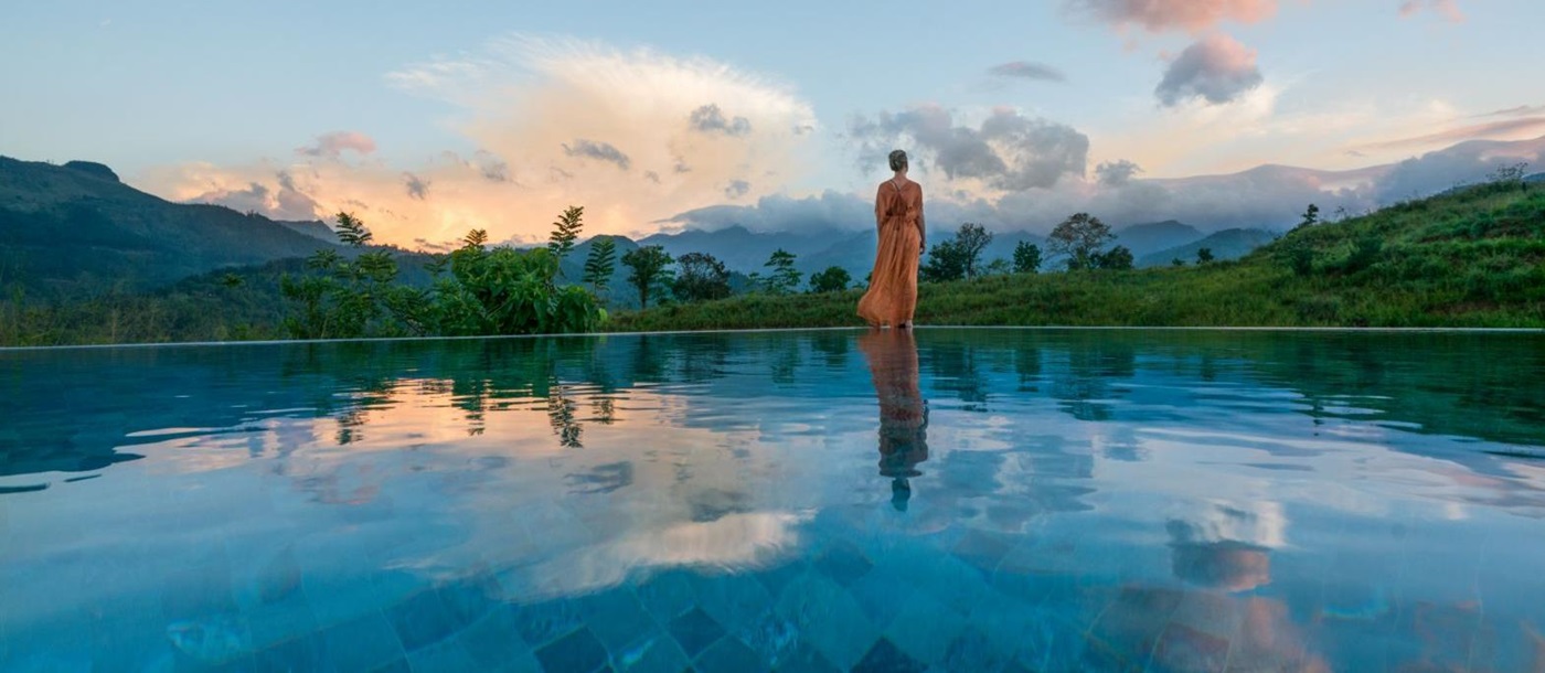 Lady admiring the views from the infinity pool at Santani Wellness Resort in Sri Lanka