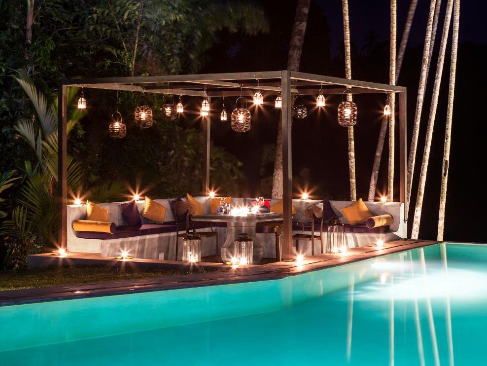 poolside seating area at night at The kandy house in Sri Lanka