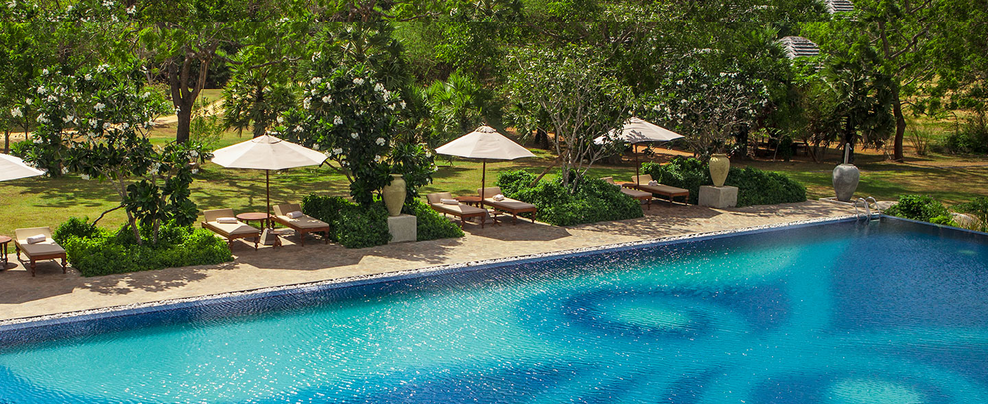 swimming pool with parasols at ulagalla, Sri Lanka