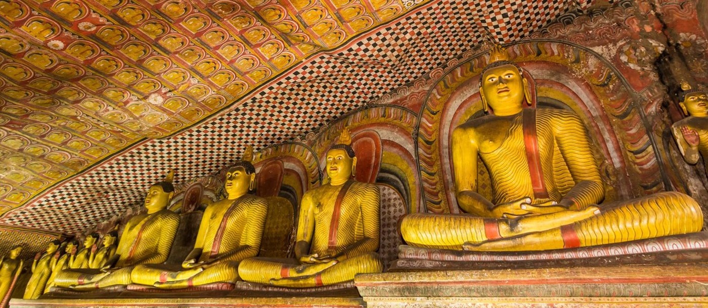 Interior of Sri Lanka's Dambulla Caves with buddhas and ornate paintings