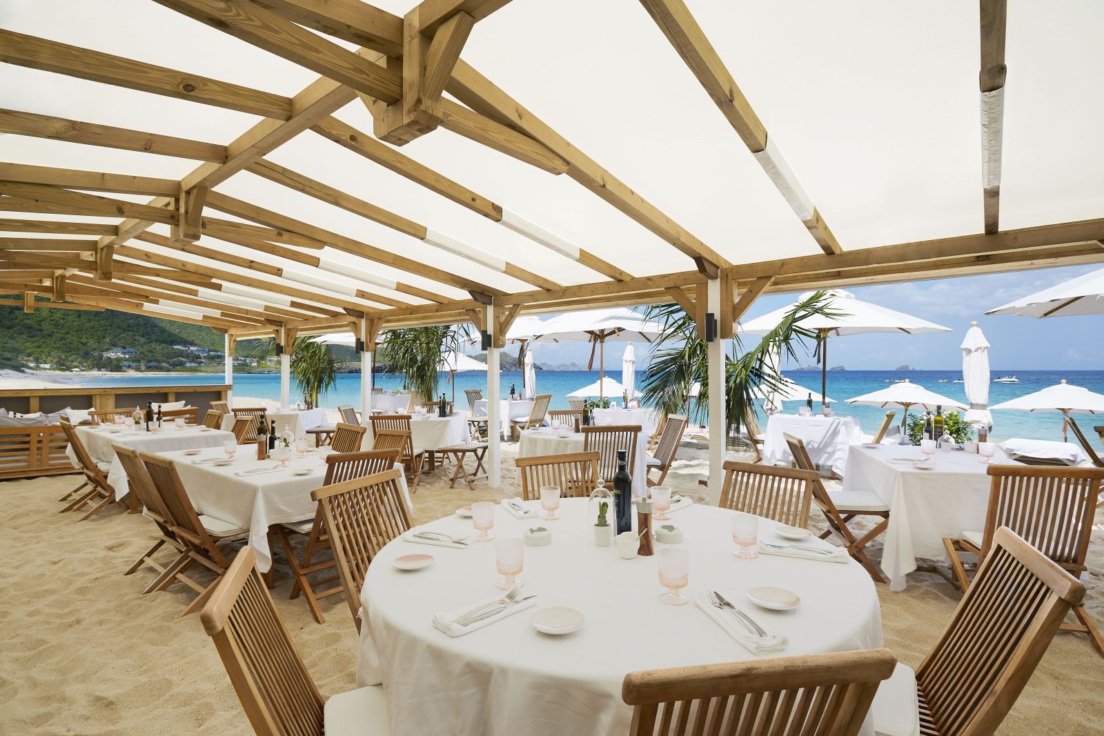 Tables and chairs on the beach in an open air cafe at Hotel Cheval Blanc in St Barths