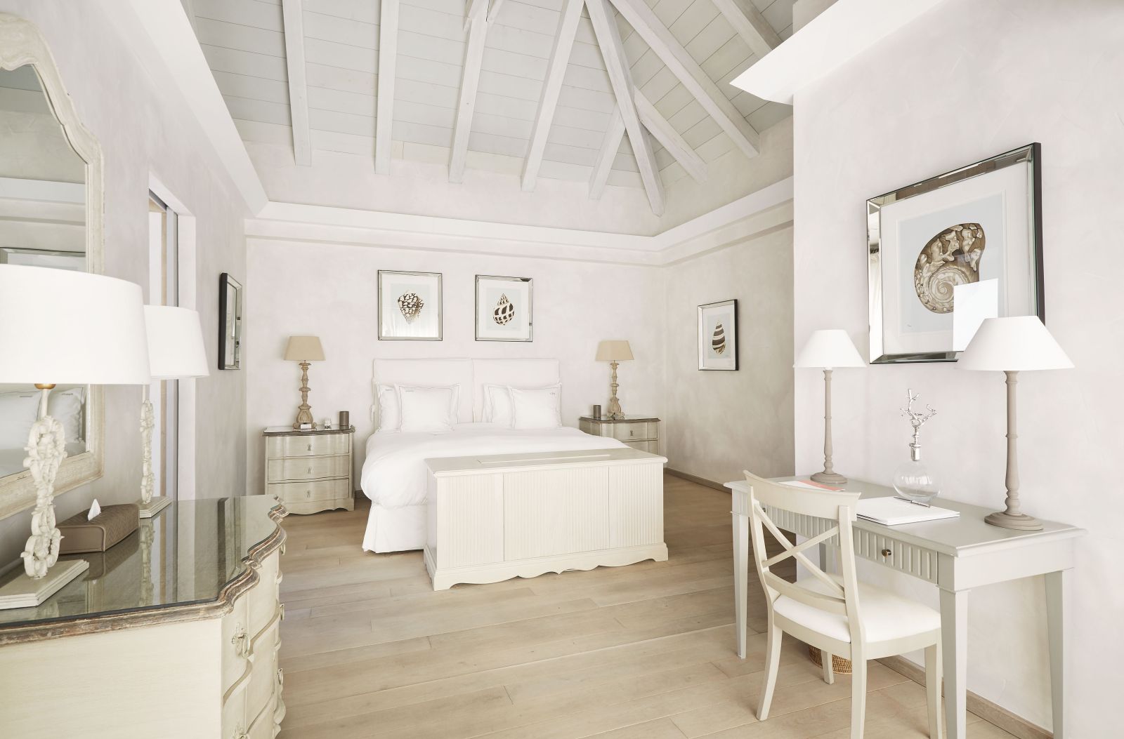 A double bedroom with white furniture and vaulted ceiling at Hotel Cheval Blanc in St Barths