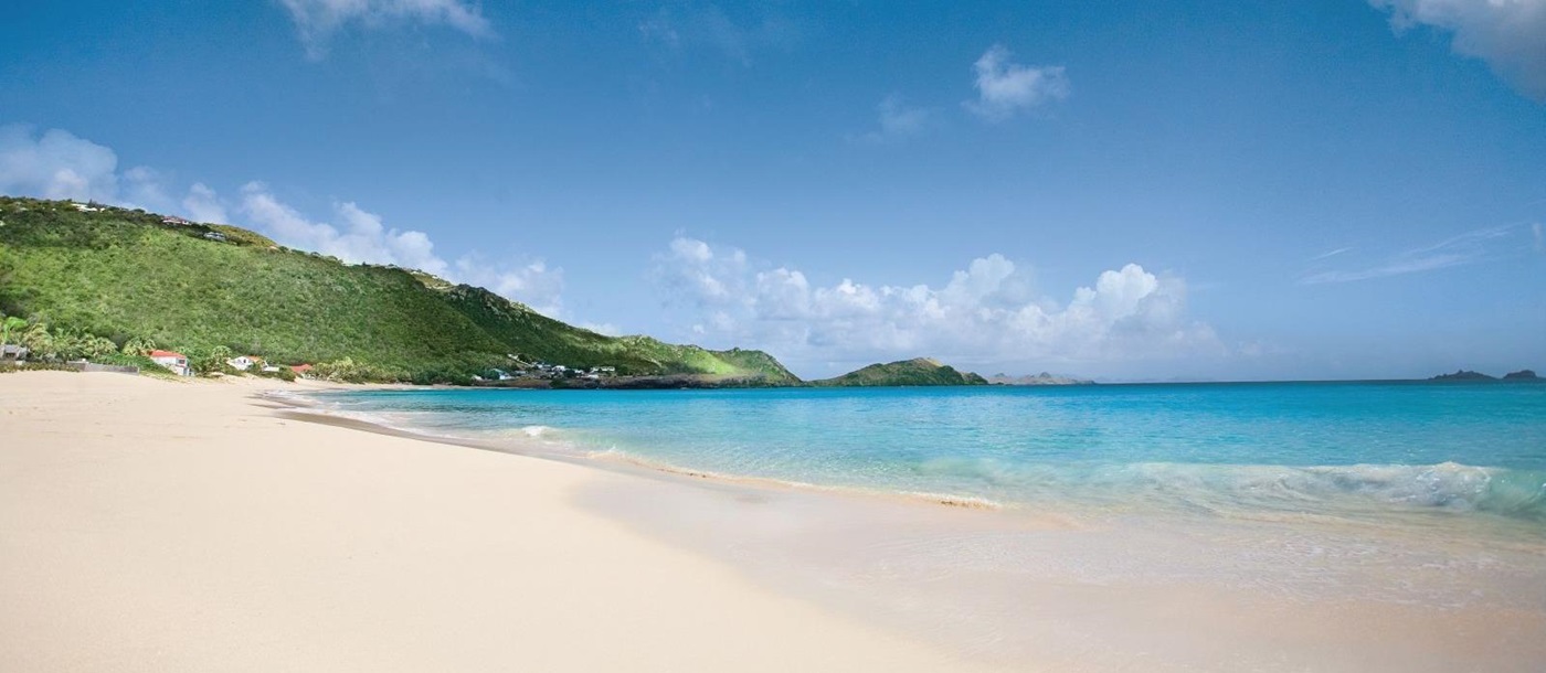 A view of the beach with white sands and blue sky at Hotel Cheval Blanc in St Barths