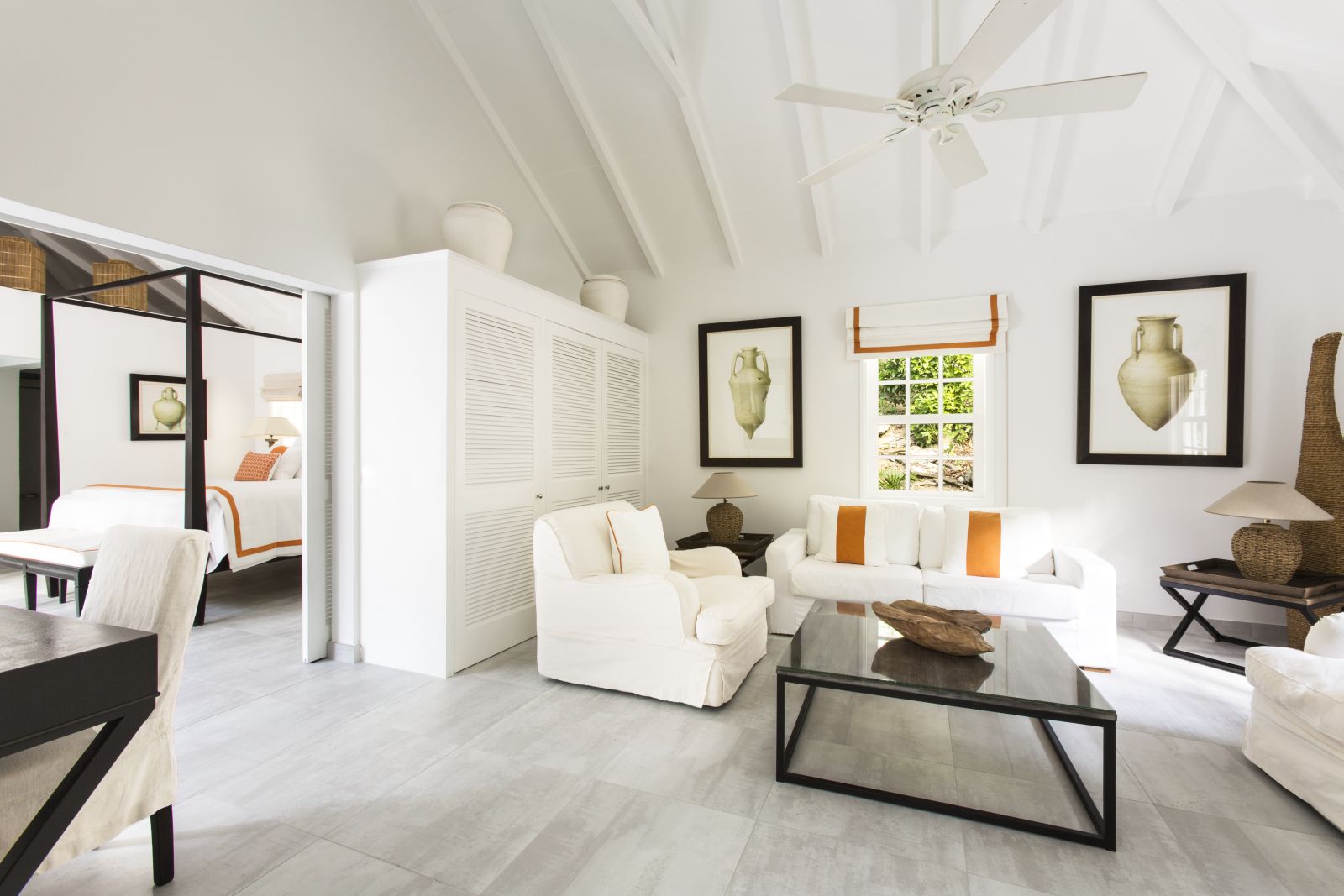 A villa with double bed and living area all decorated in white at Hotel Cheval Blanc in St Barths