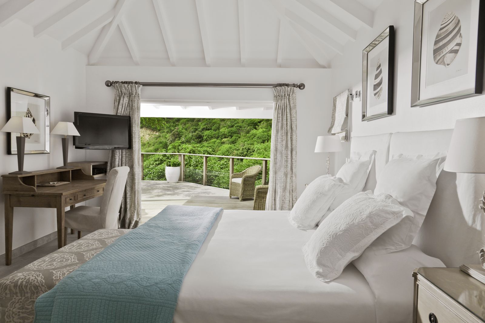 A double room at Hotel Cheval Blanc in St Barths with a large outside decking area overlooking the garden