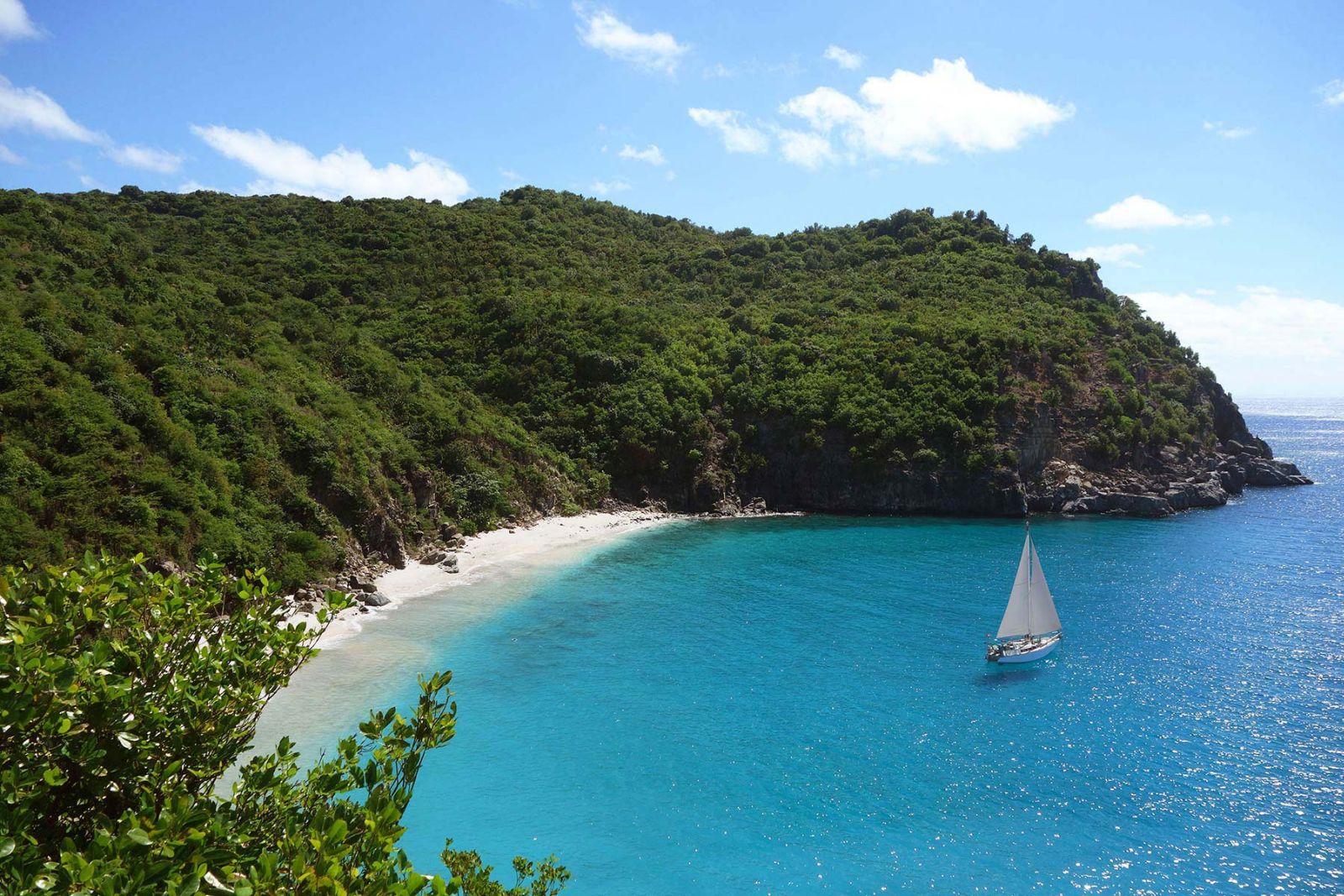 A boat sailing in blue waters near the beach at Hotel Cheval Blanc in St Barths
