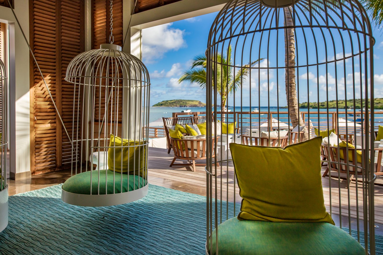 Two swinging chairs suspended from the ceiling overlooking the patio at Le Barthelemy Hotel & Spa in St Barths