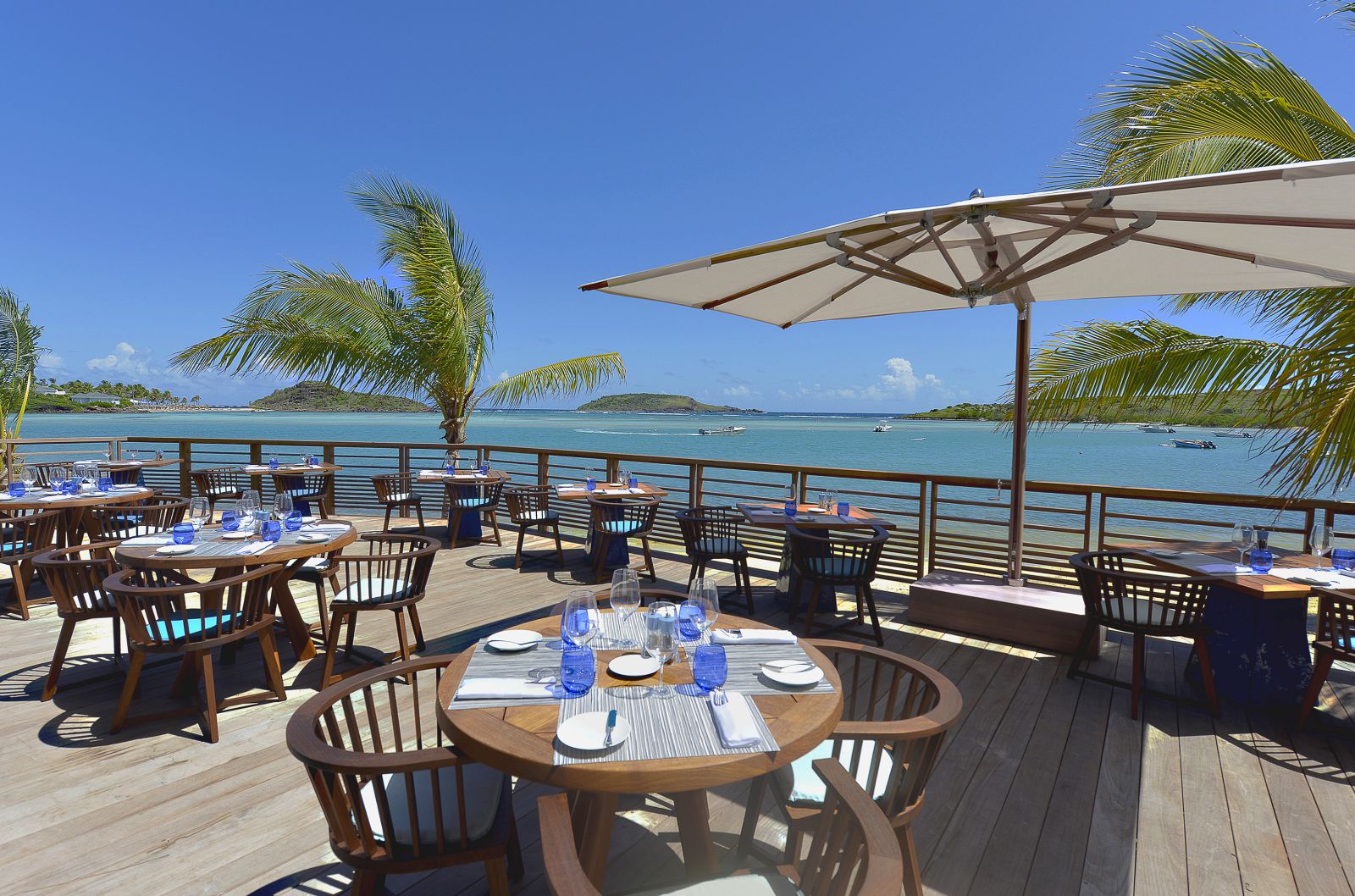 Tables on an outdoor decking area at Le Barthelemy Hotel & Spa in St Barths