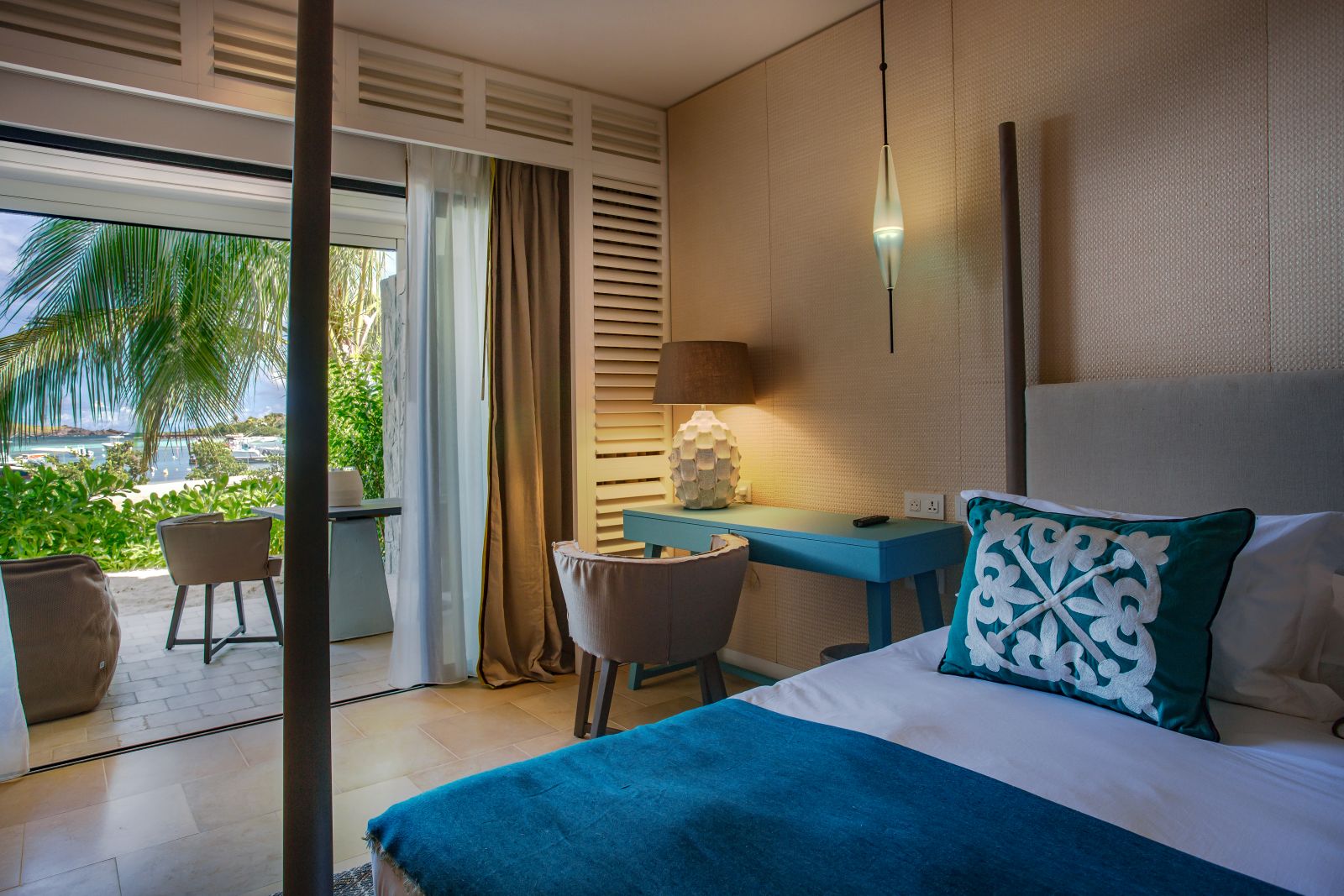 A bedroom with double bed and outside patio at Le Barthelemy Hotel & Spa in St Barths
