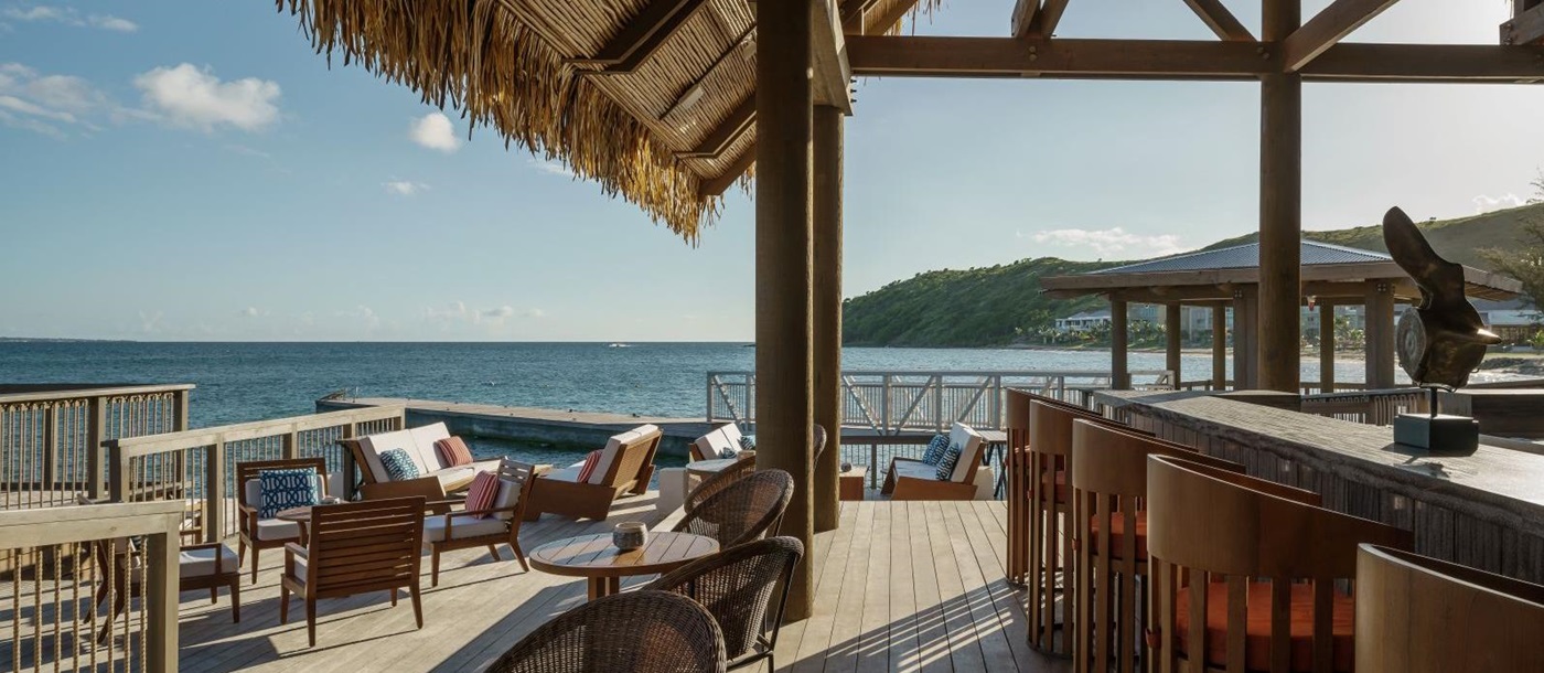 The bar and seating area on the decking overlooking the sea at the Park Hyatt St. Kitts Christophe Harbour Hotel