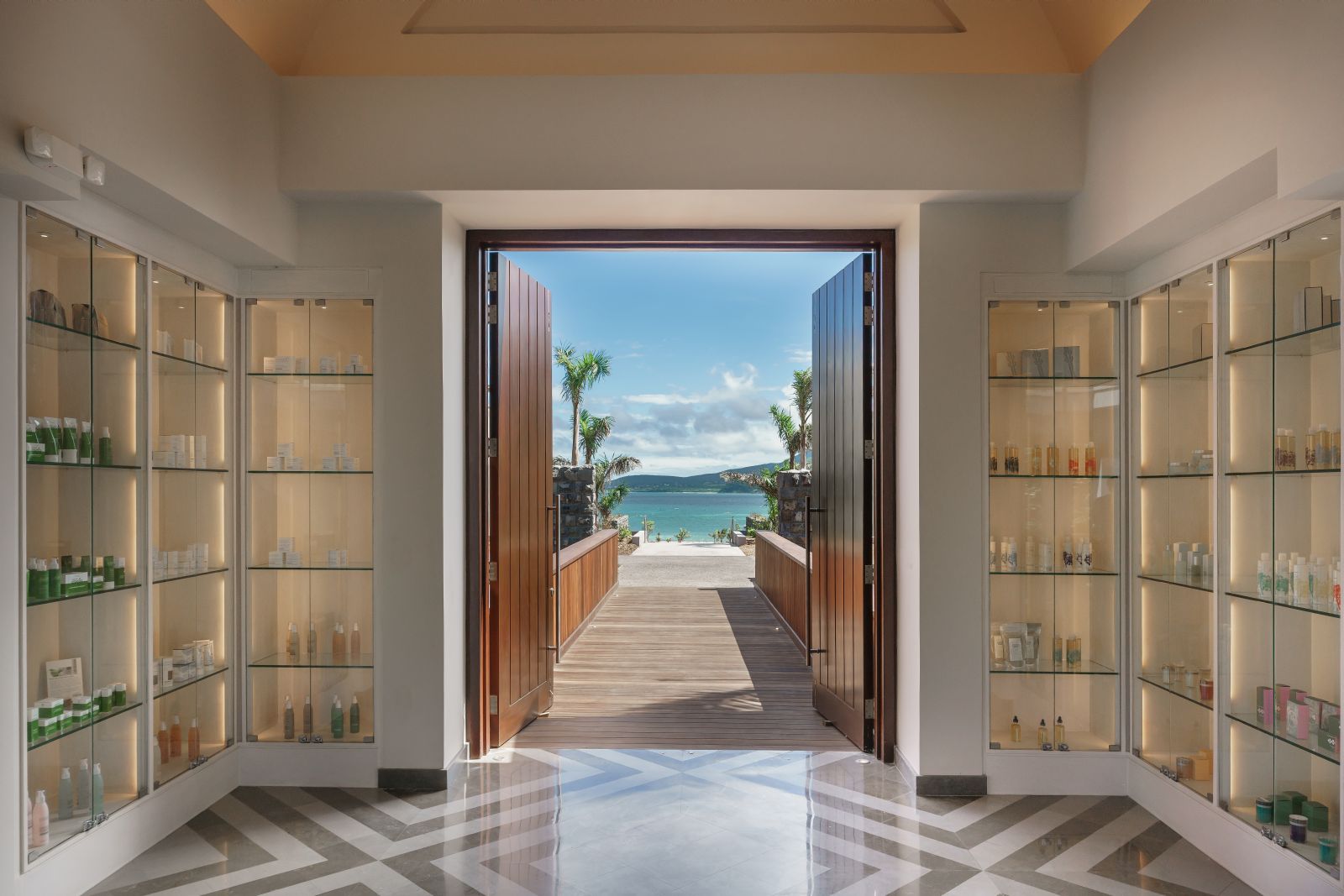 The enterance to the spa with a view of the beach at the end of a walkway at the Park Hyatt St. Kitts Christophe Harbour Hotel