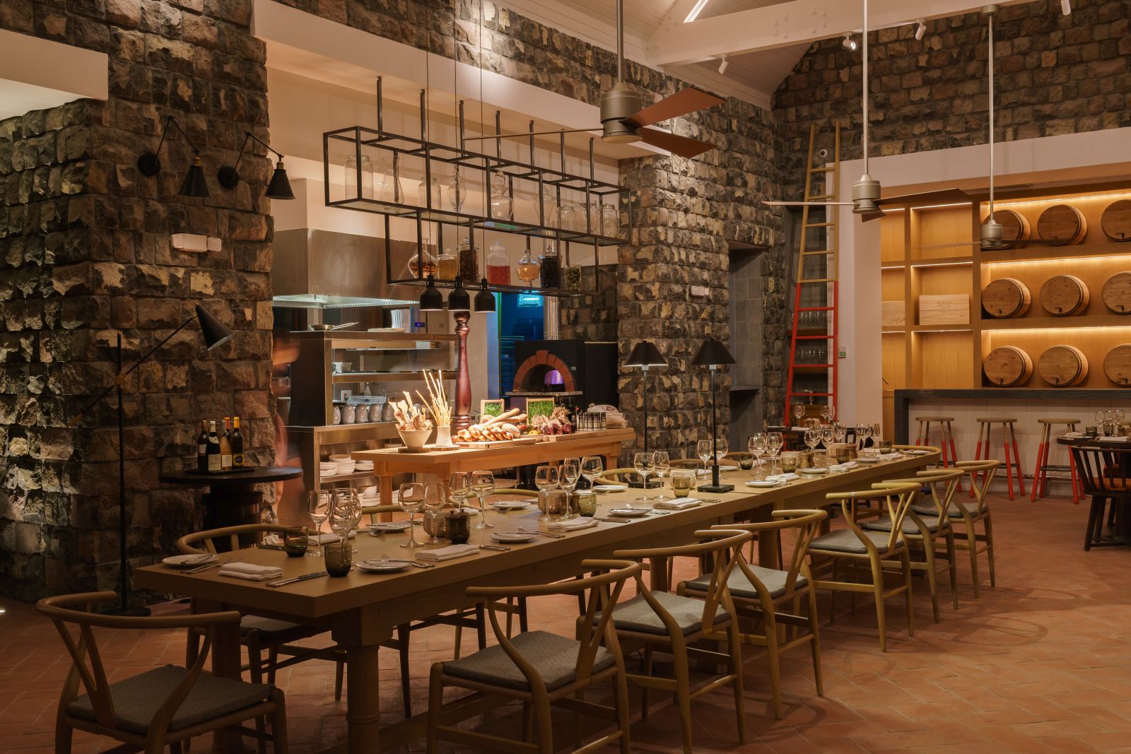 A long dining table with wooden chairs in the Stone Barn at the Park Hyatt St. Kitts Christophe Harbour Hotel