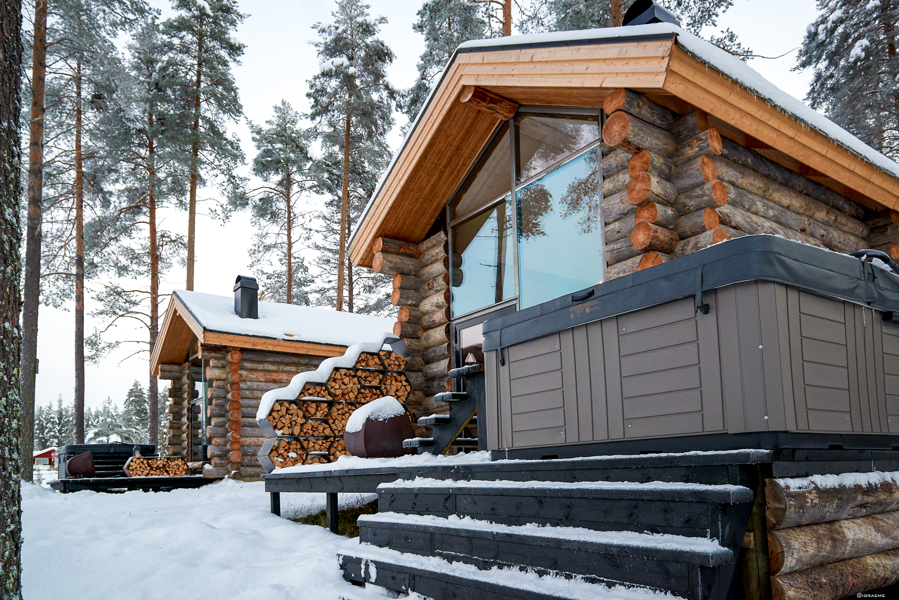 Exterior view of a guest cabin and jacuzzi at Arctic Retreat in Swedish Lapland