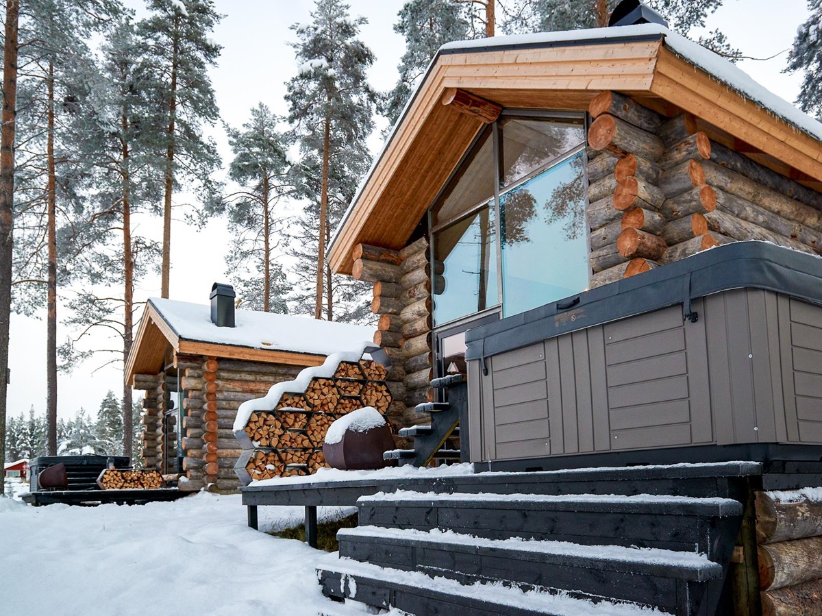 Exterior view of a guest cabin and jacuzzi at Arctic Retreat in Swedish Lapland