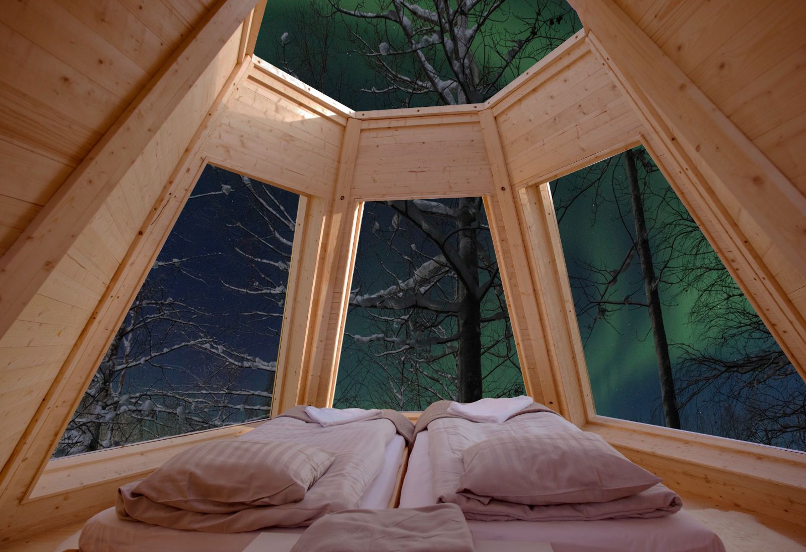 The bed of a Cone Room looking out on Northern Lights at Aurora Safari Camp in Sweden