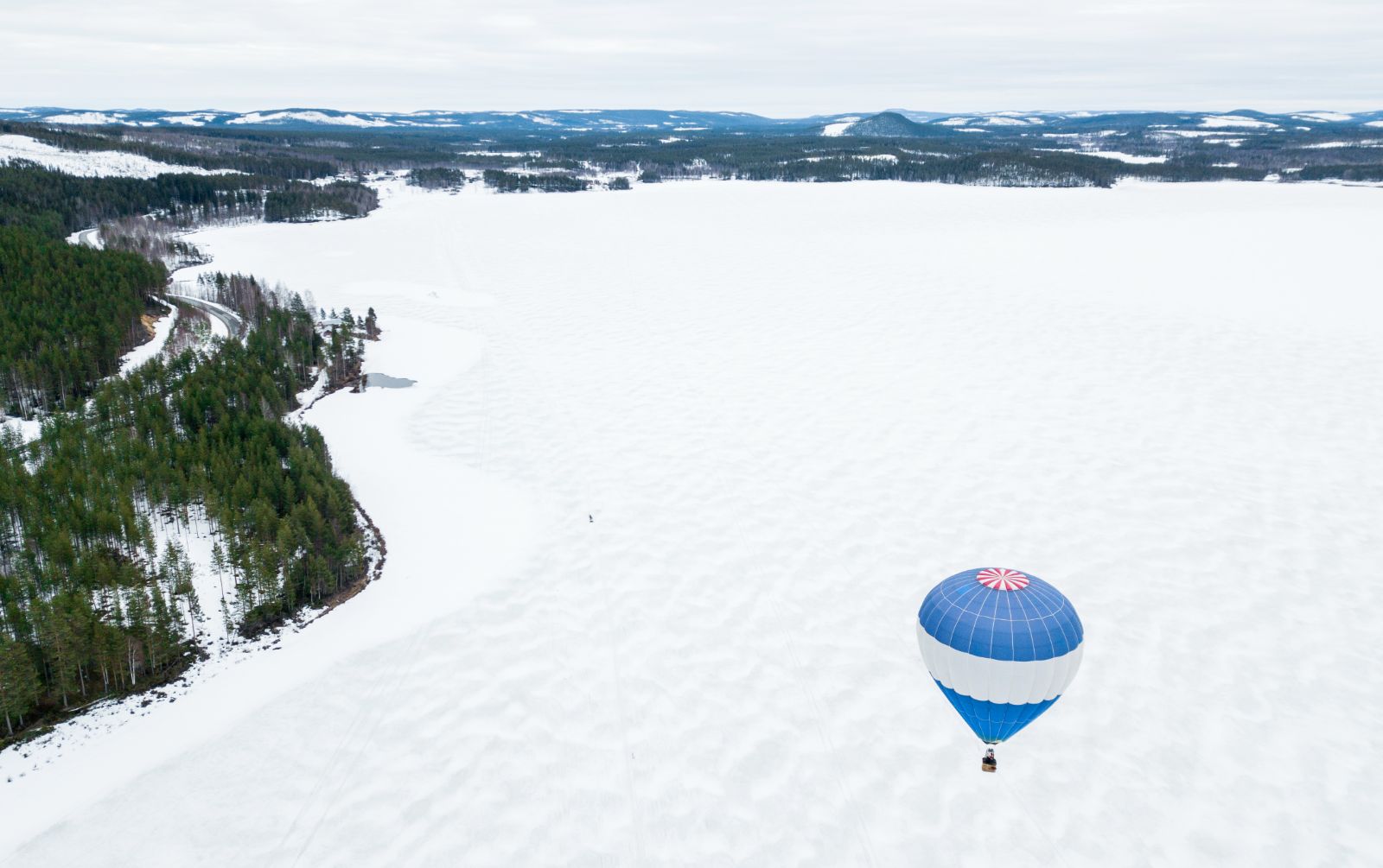 Hot Air Balloon flying over the snowy plain at Aurora Safari Camp in Sweden