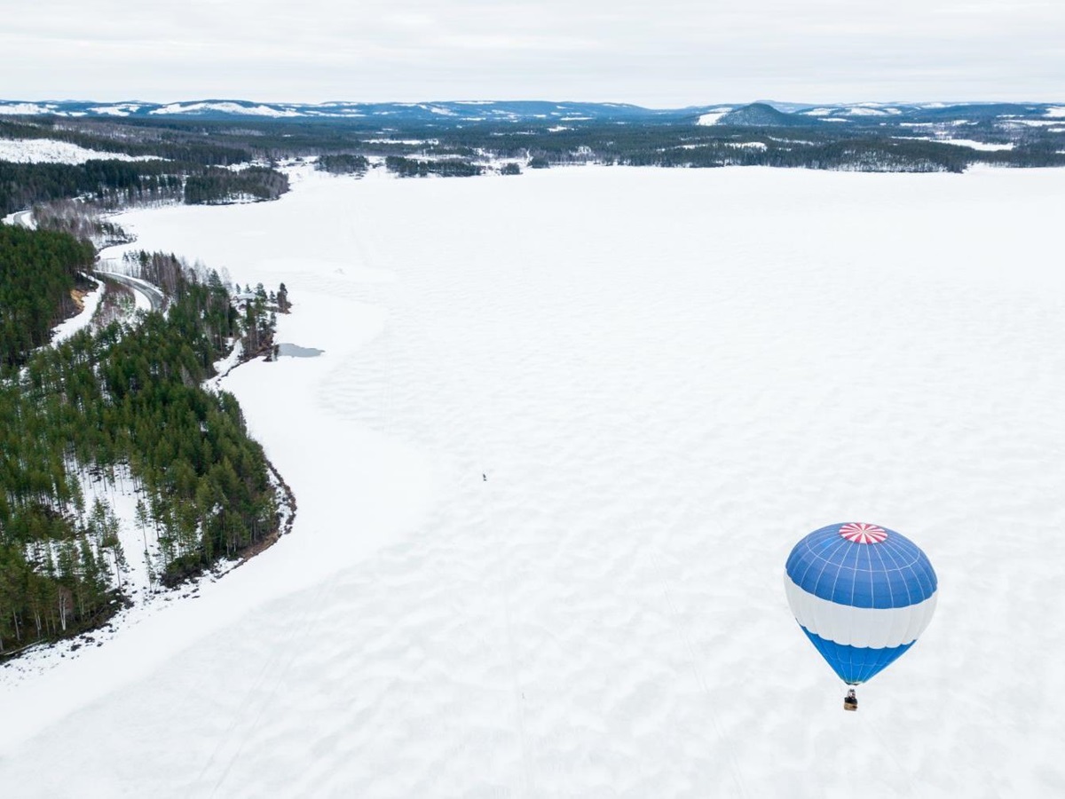 Hot Air Balloon flying over the snowy plain at Aurora Safari Camp in Sweden