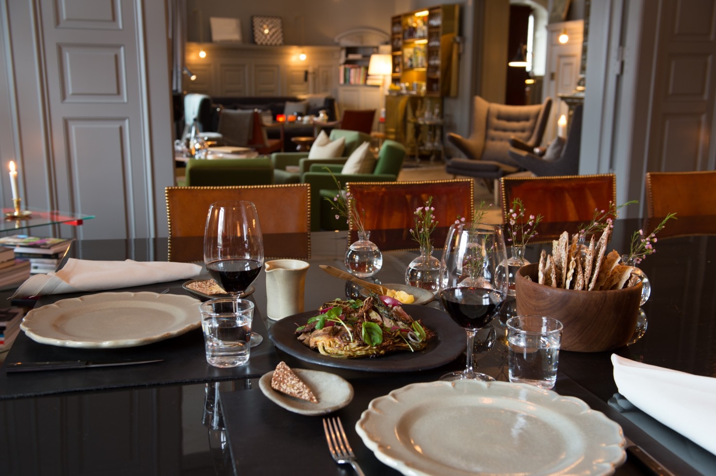 Set dinner table with lounge in the background