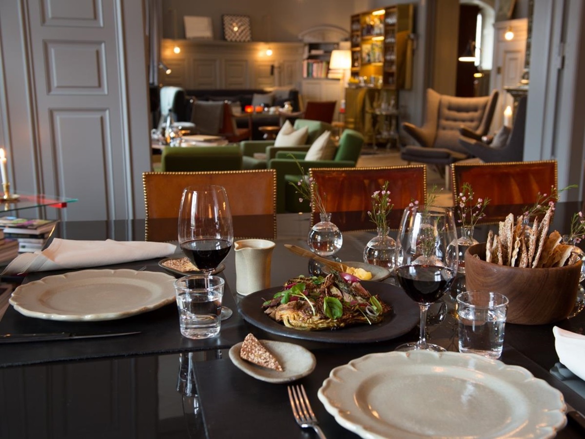 Set dinner table with lounge in the background