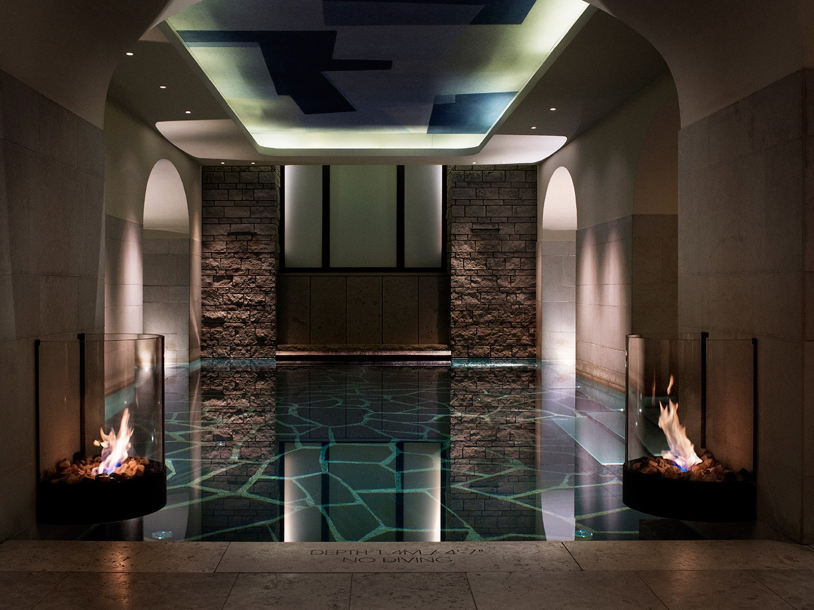Indoor pool with mood lighting and fire in glass bowls