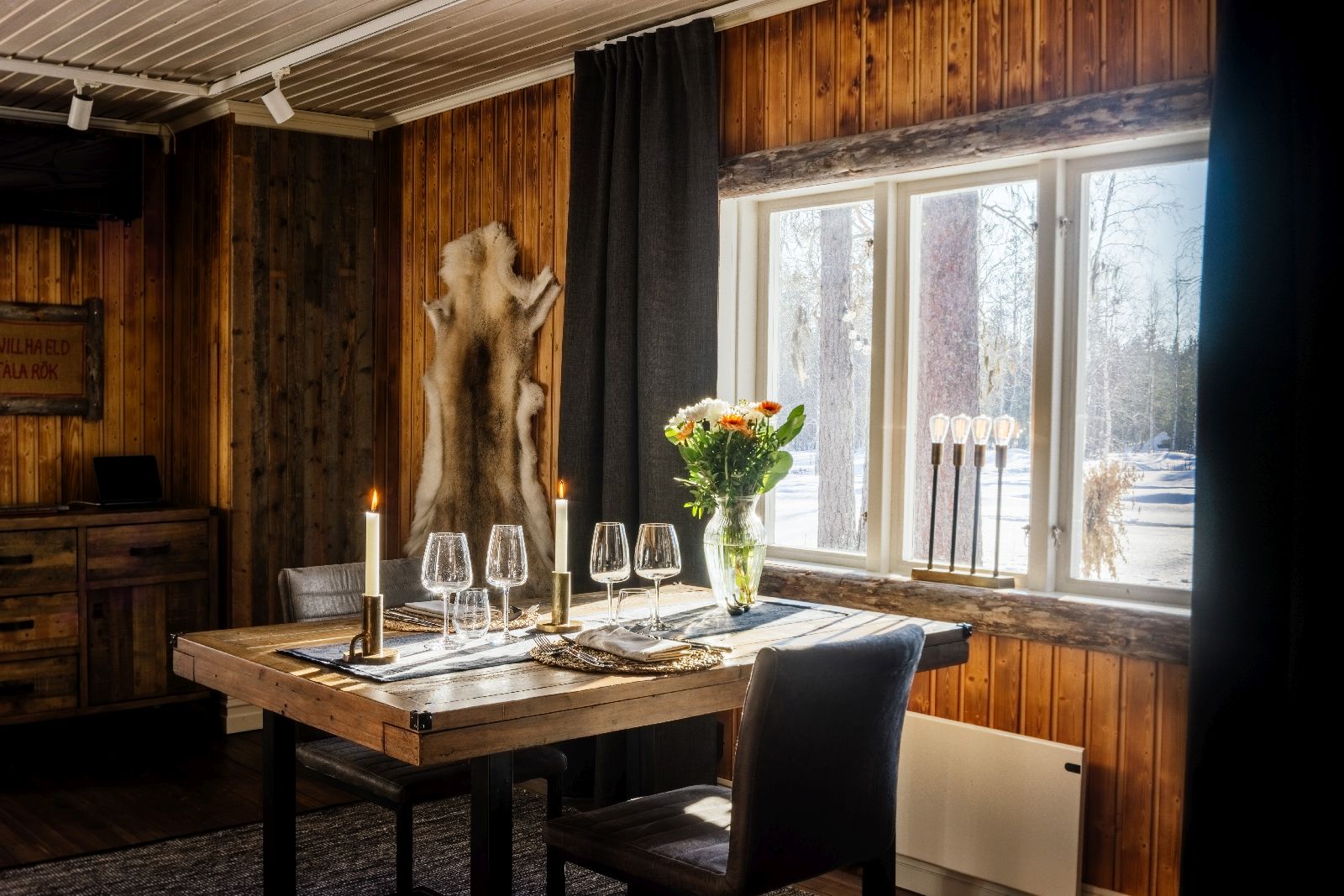 Cosy candlelit dining area in luxury Loggers Lodge hotel in Sweden