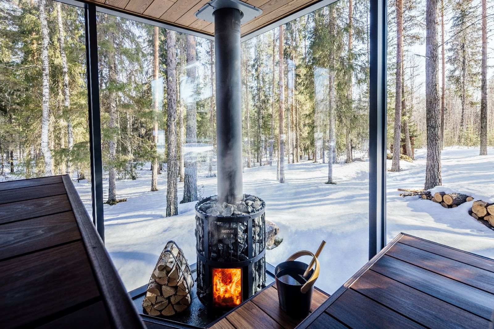 Interior view of private sauna with forest and snow views at luxury Loggers Lodge hotel in Sweden