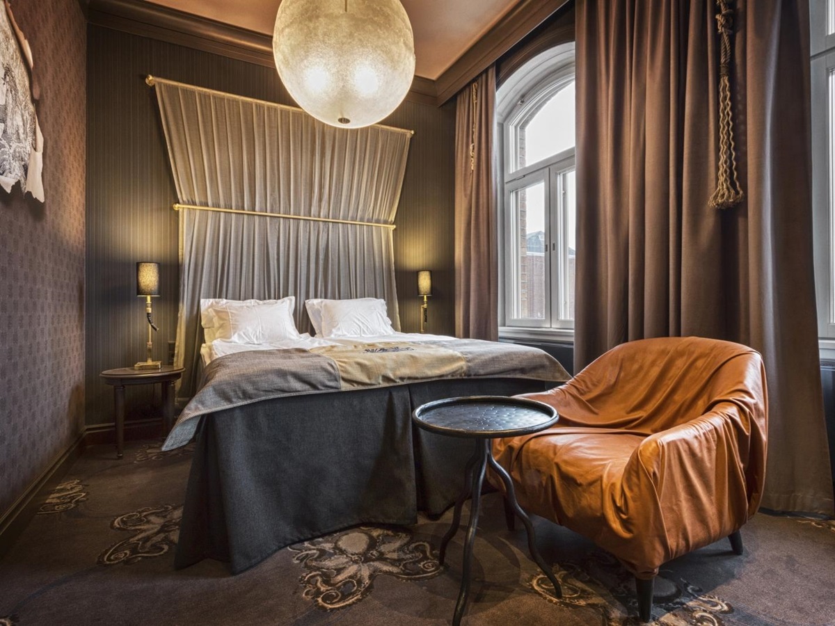 Double Bed with chair and small table at Stora Hotellet