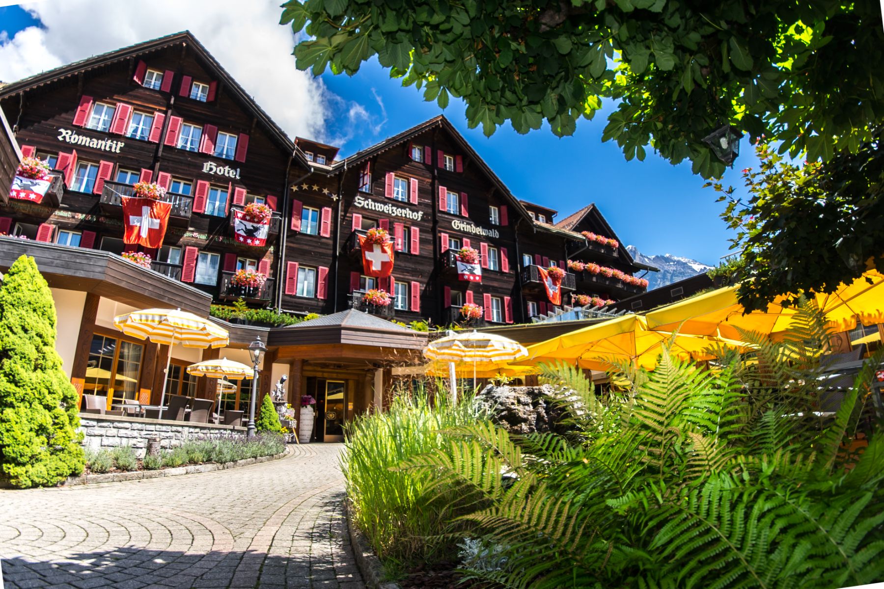 Exterior view of Hotel Schweizerhof in Zermatt during the summer