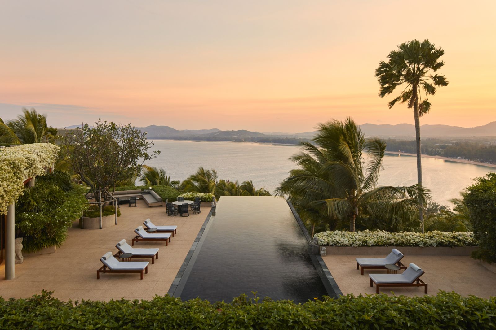 Sunset overlooking a pool and the ocean at luxury resort Amanpuri