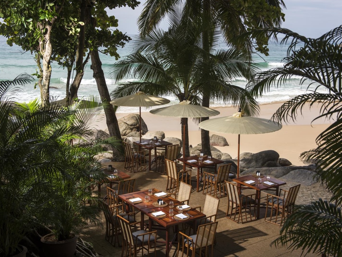 Beach dining set-up with parasols at Amanpuri