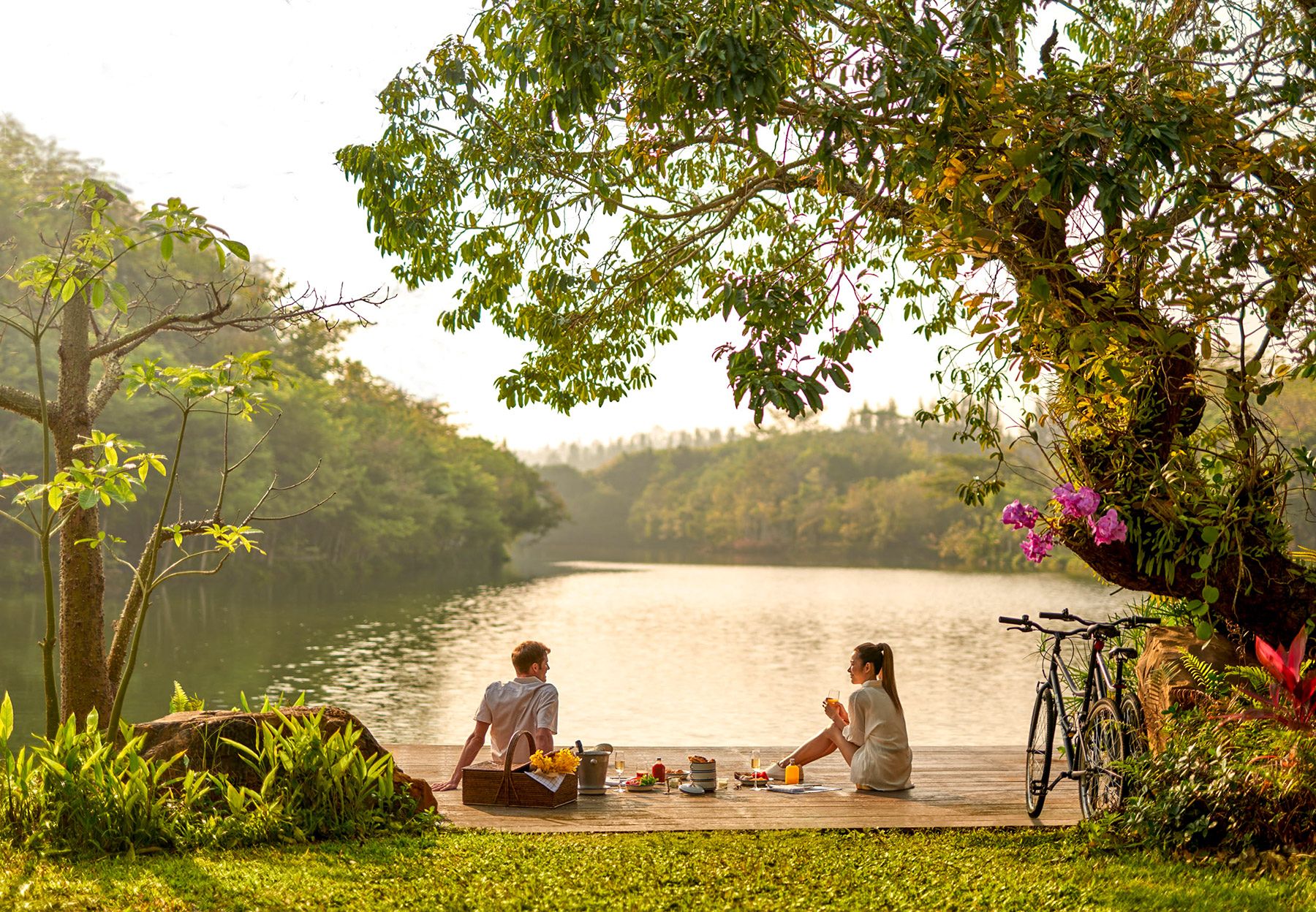 A couple resting by Swan Lake on a bicycle tour from Intercontinental Khao Yai Resort in Thailand