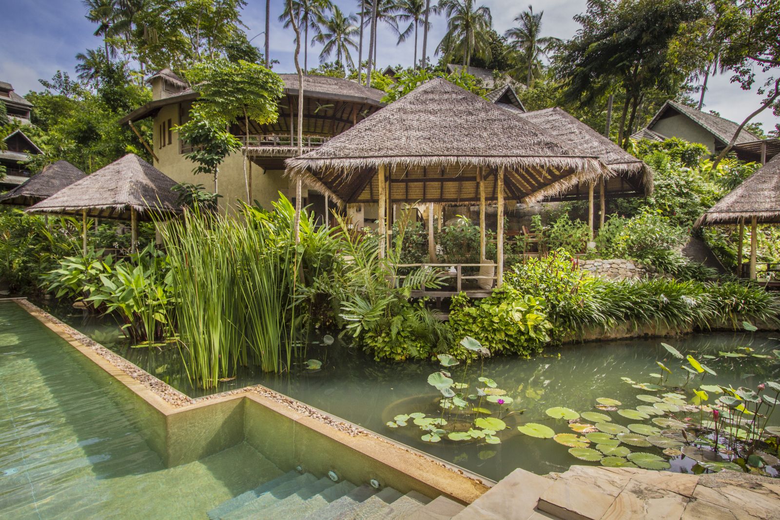 Thatch-roofed terraces by the water at luxury resort Kamalaya in Koh Samui, Thailand