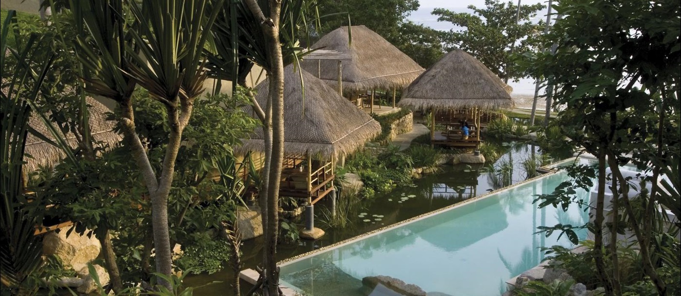 Pool and rooms hidden in the lush gardens at at luxury wellness resort Kamalaya in Thailand