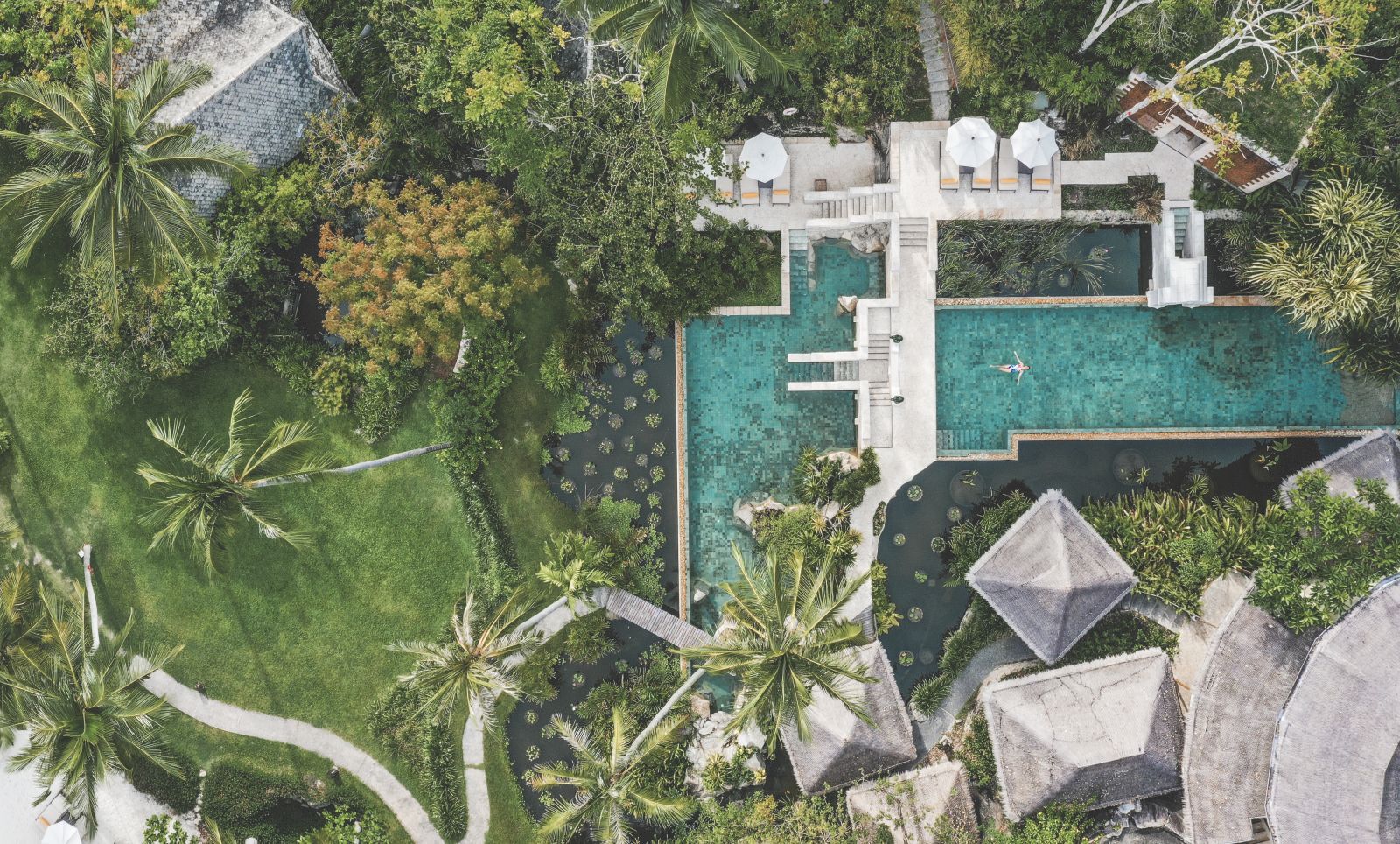 Aerial view of the leisure pool at at luxury wellness resort Kamalaya in Thailand and the surrounding lush gardens