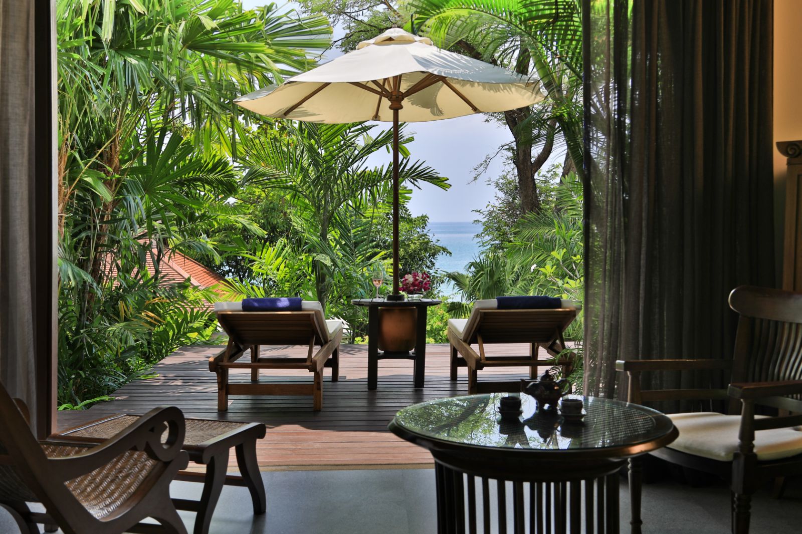 Outdoor terrace area surrounded by palm tree in a pavilion suite at luxury resort Pimalai 