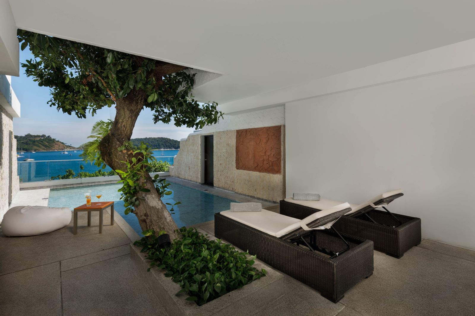 Family guest suite terrace with sunbeds and pool at The Nai Harn resort in the Phuket region of Thailand